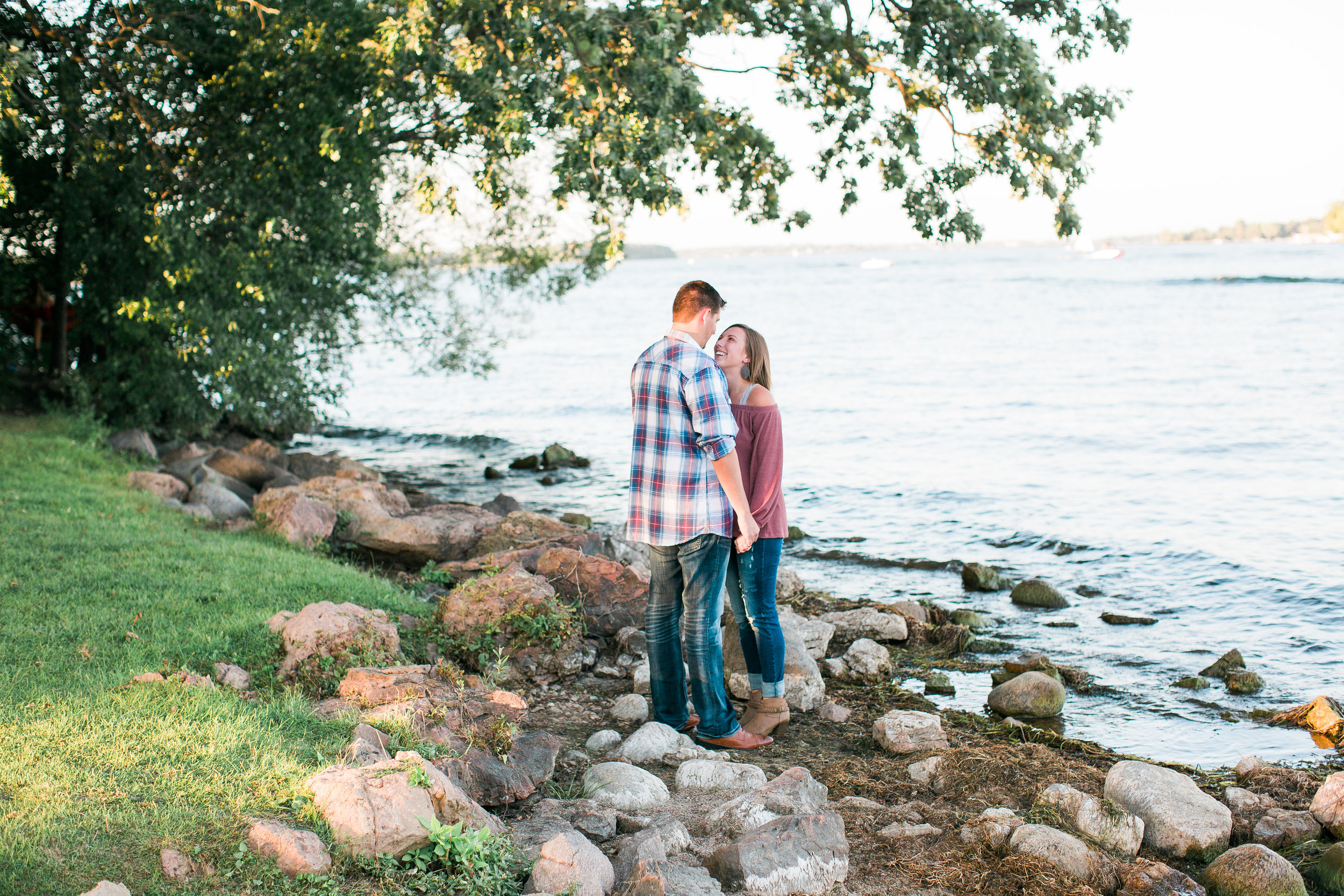 Engaged couple holding hands on Lake Minnetonka in Excelsior Minnesota for engagement photos Minnesota engagement photographer Mallory Kiesow Photography