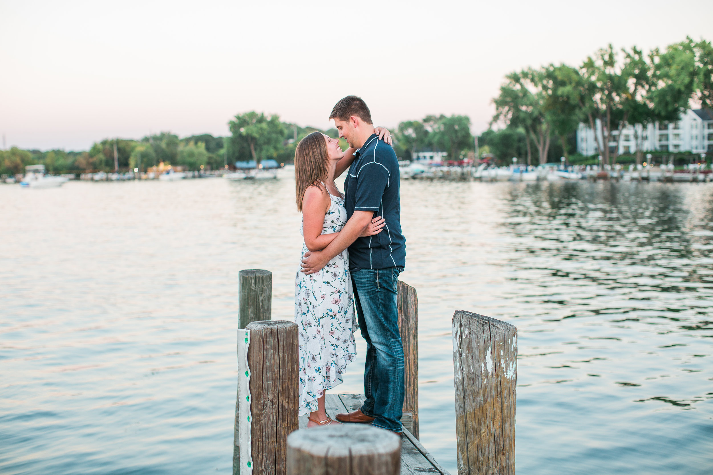 Engaged couple in Excelsior Minnesota on Lake Minnetonka dock kissing at sunset Minnesota engagement photographer Mallory Kiesow Photography