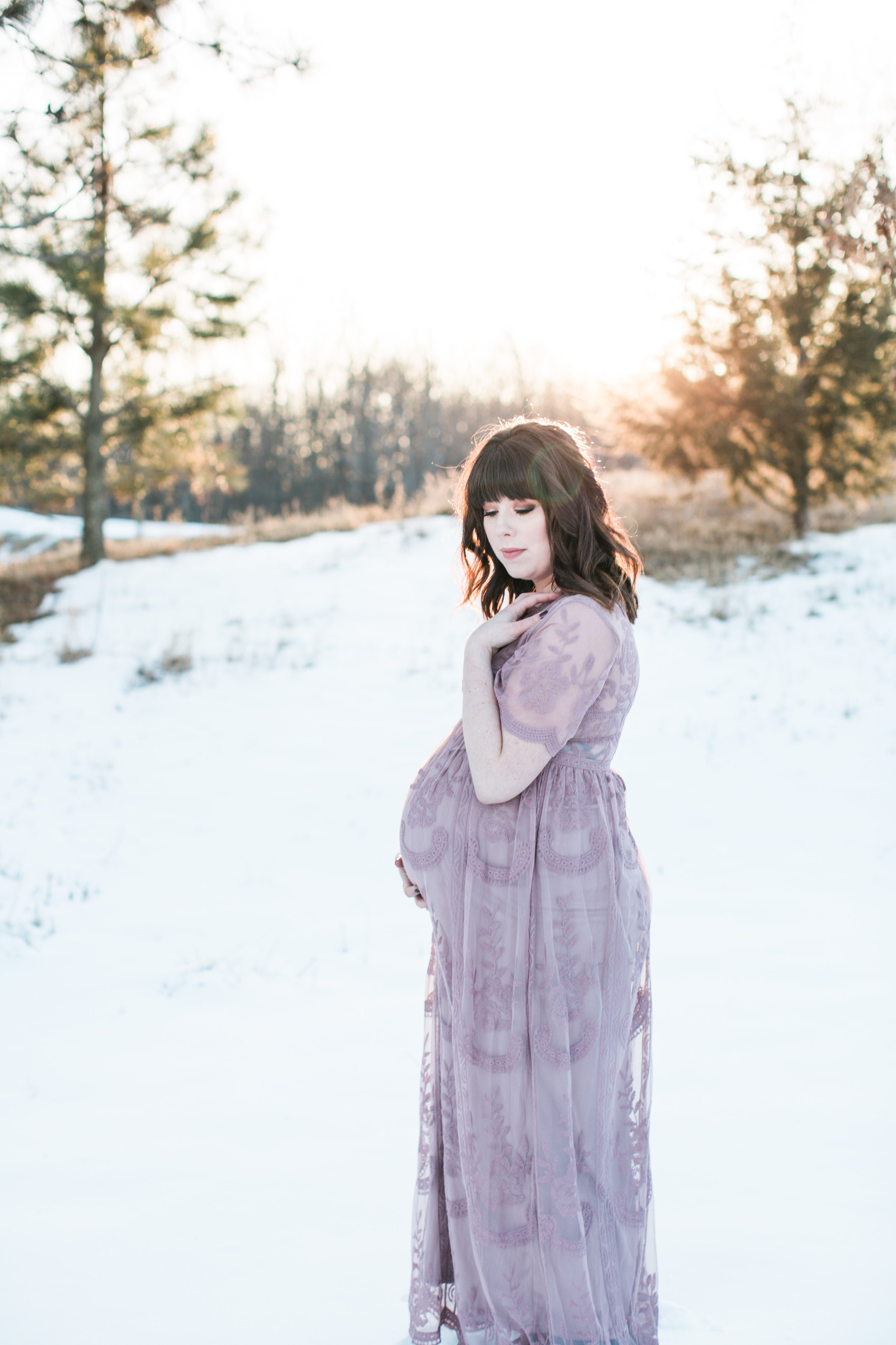 Expecting mother in pink lace dress in winter maternity photos at sunset Minnesota maternity photographer Mallory Kiesow Photography