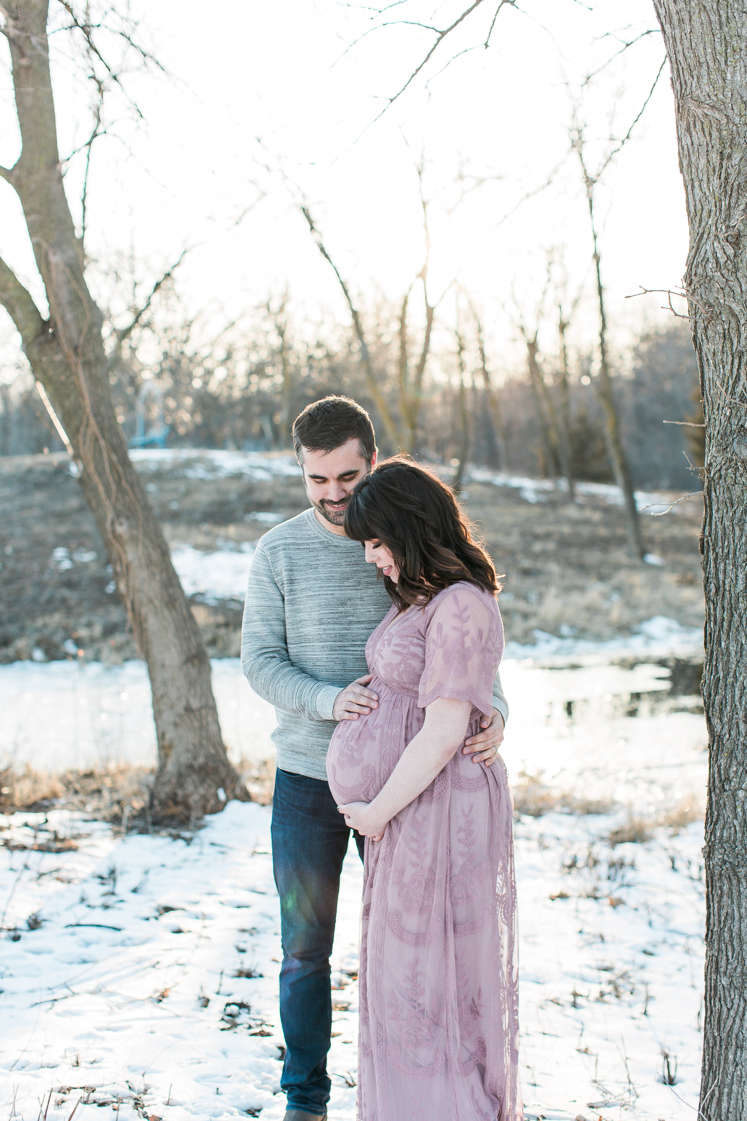 Pregnant mother and soon to be father holding baby bump in winter maternity session Minnesota maternity photographer Mallory Kiesow Photography