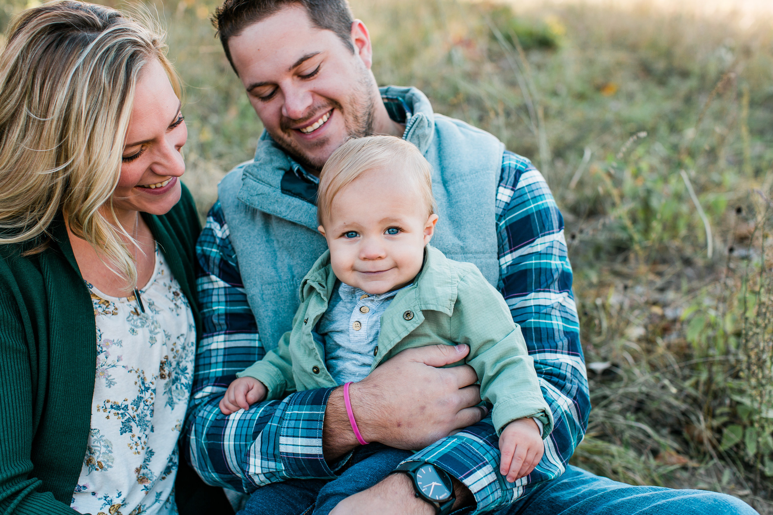 Family of mom dad and baby boy sitting in fall family session Minnesota family photographer Mallory Kiesow Photography