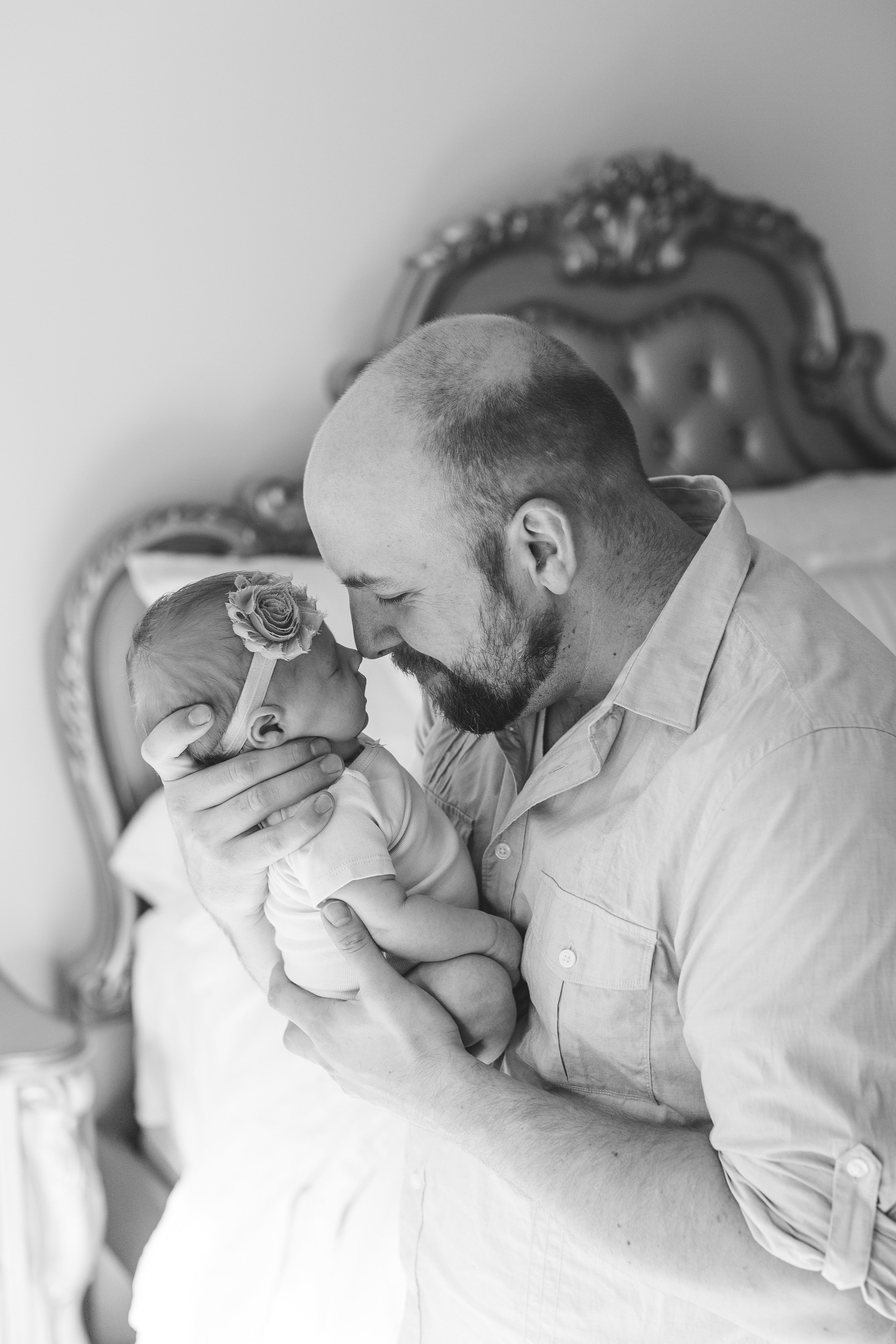 Dad and newborn baby girl snuggling in black and white photo in bedroom for in-home lifestyle newborn session Minnesota newborn photographer Mallory Kiesow Photography