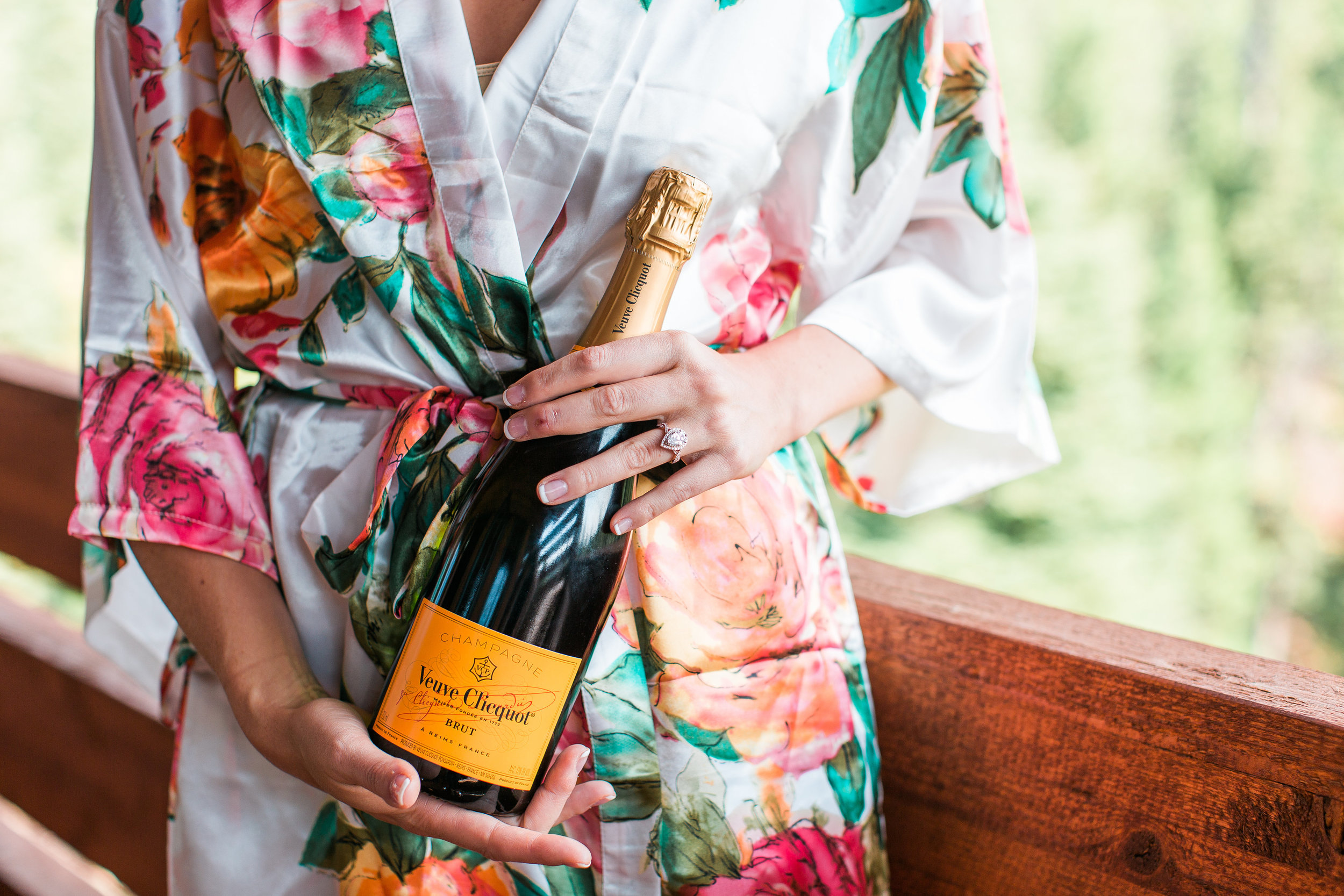 Bride with floral robe holding champagne bottle on wedding day Minnesota wedding photography Mallory Kiesow Photography