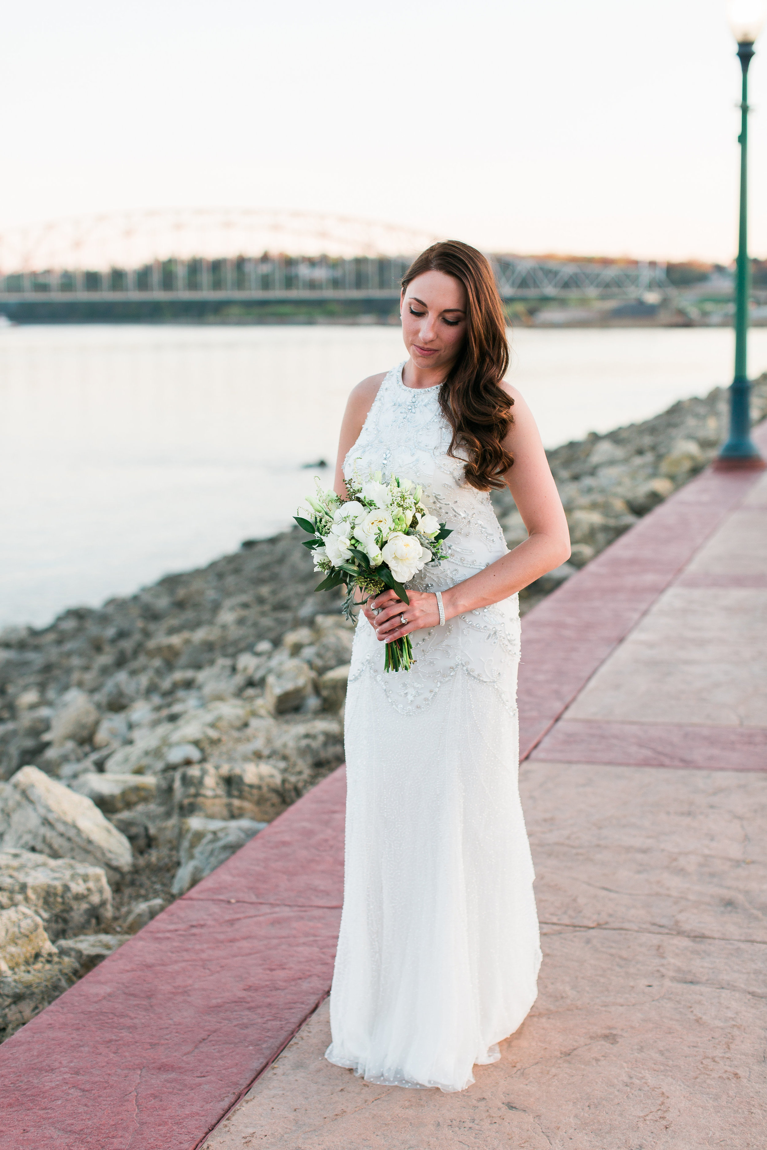 Bridal portrait of bride with beaded dress hair down along riverside in Dubuque Iowa wedding Minnesota wedding photography Mallory Kiesow Photography