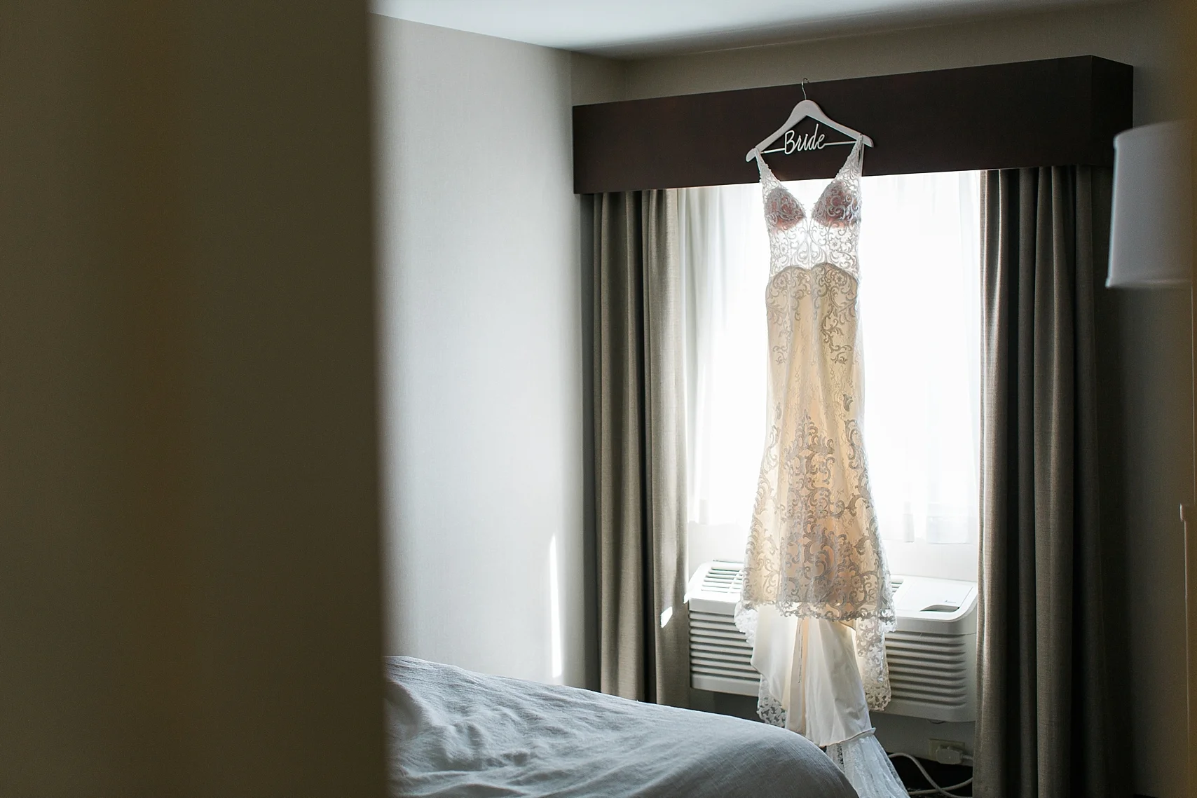 Wedding dress in hotel room window for wedding at the Chart House Summer Wedding Lakeville Minnesota Minneapolis Wedding Photographer Mallory Kiesow