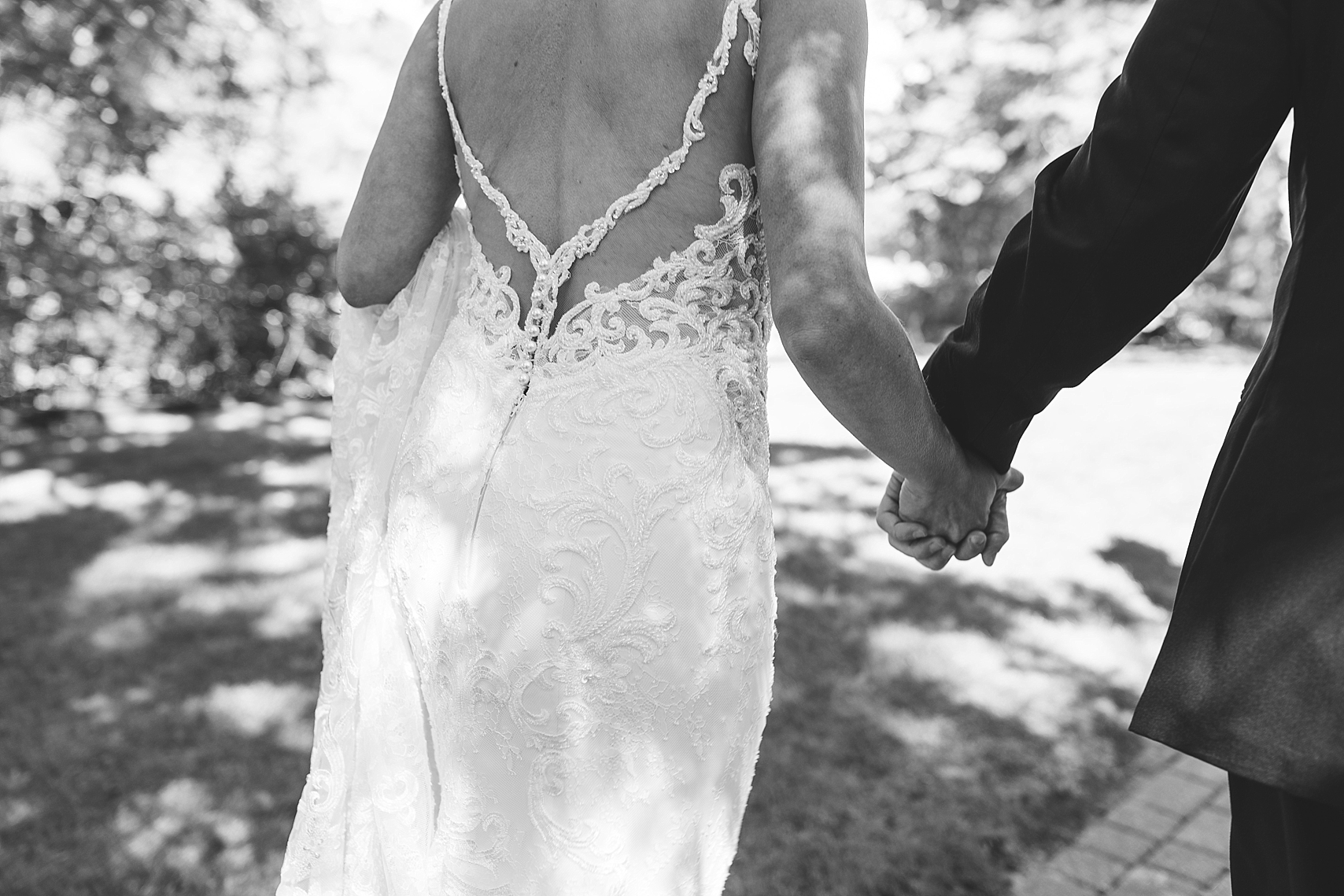 Bride and groom walking holding hands in black and white on wedding day at the Chart House Summer Wedding Lakeville Minnesota Minneapolis Wedding Photographer Mallory Kiesow