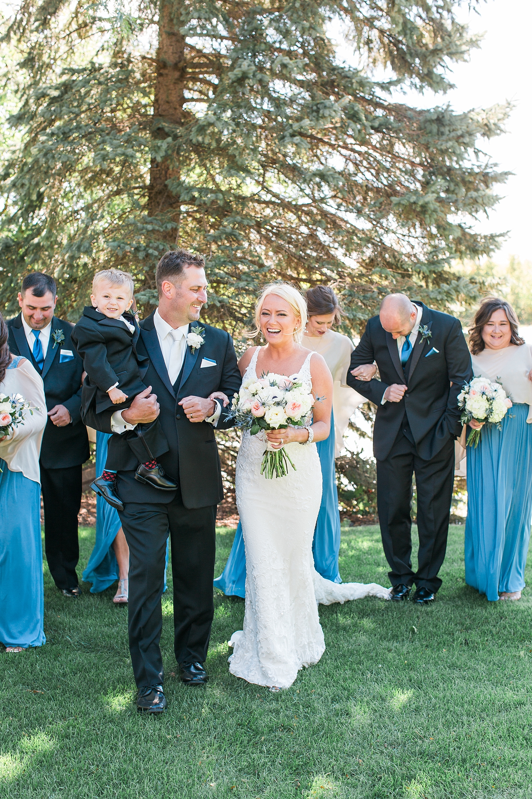 Wedding party black suits blue dresses walking and laughing on wedding day at the Chart House Summer Wedding Lakeville Minnesota Minneapolis Wedding Photographer Mallory Kiesow