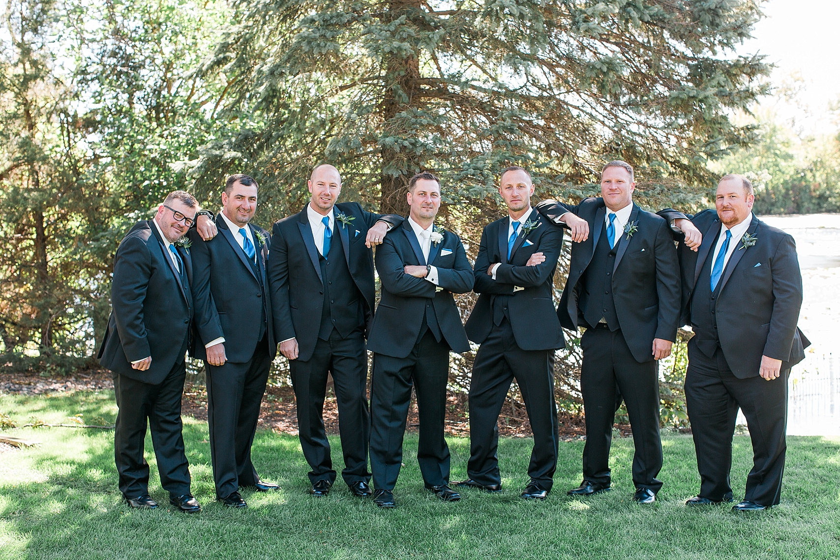 Groom and groomsmen in black suits suits on wedding day at the Chart House Summer Wedding Lakeville Minnesota Minneapolis Wedding Photographer Mallory Kiesow