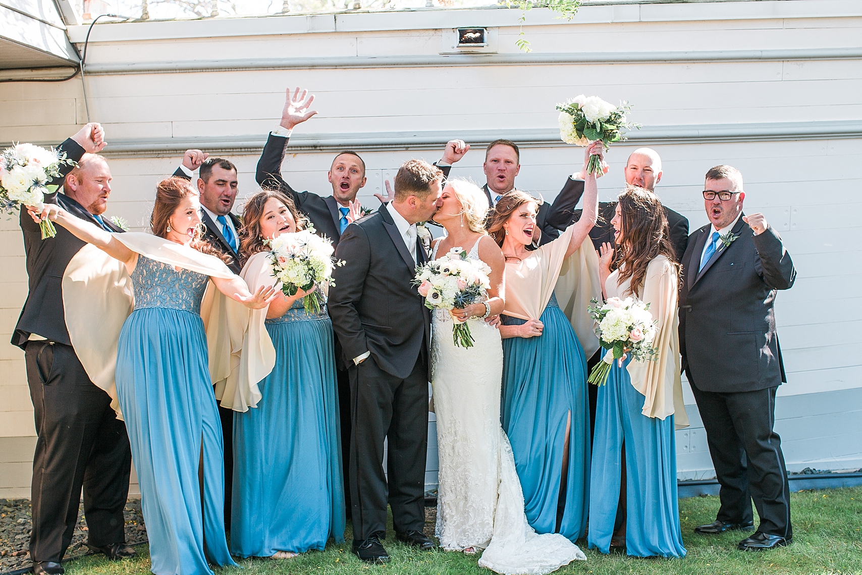 Wedding party cheering in black suits suits and blue dresses on wedding day at the Chart House Summer Wedding Lakeville Minnesota Minneapolis Wedding Photographer Mallory Kiesow