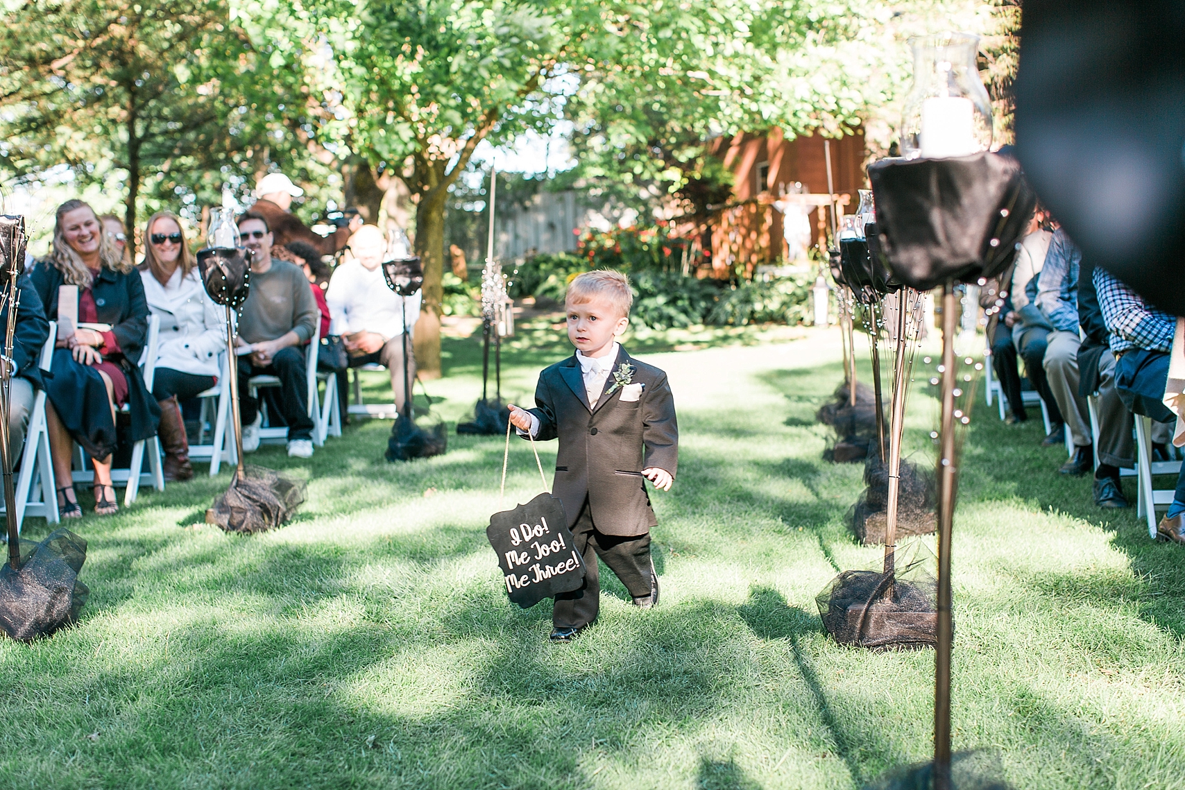 Outdoor wedding ceremony ring bearer walking down aisle at the Chart House Summer Wedding Lakeville Minnesota Minneapolis Wedding Photographer Mallory Kiesow