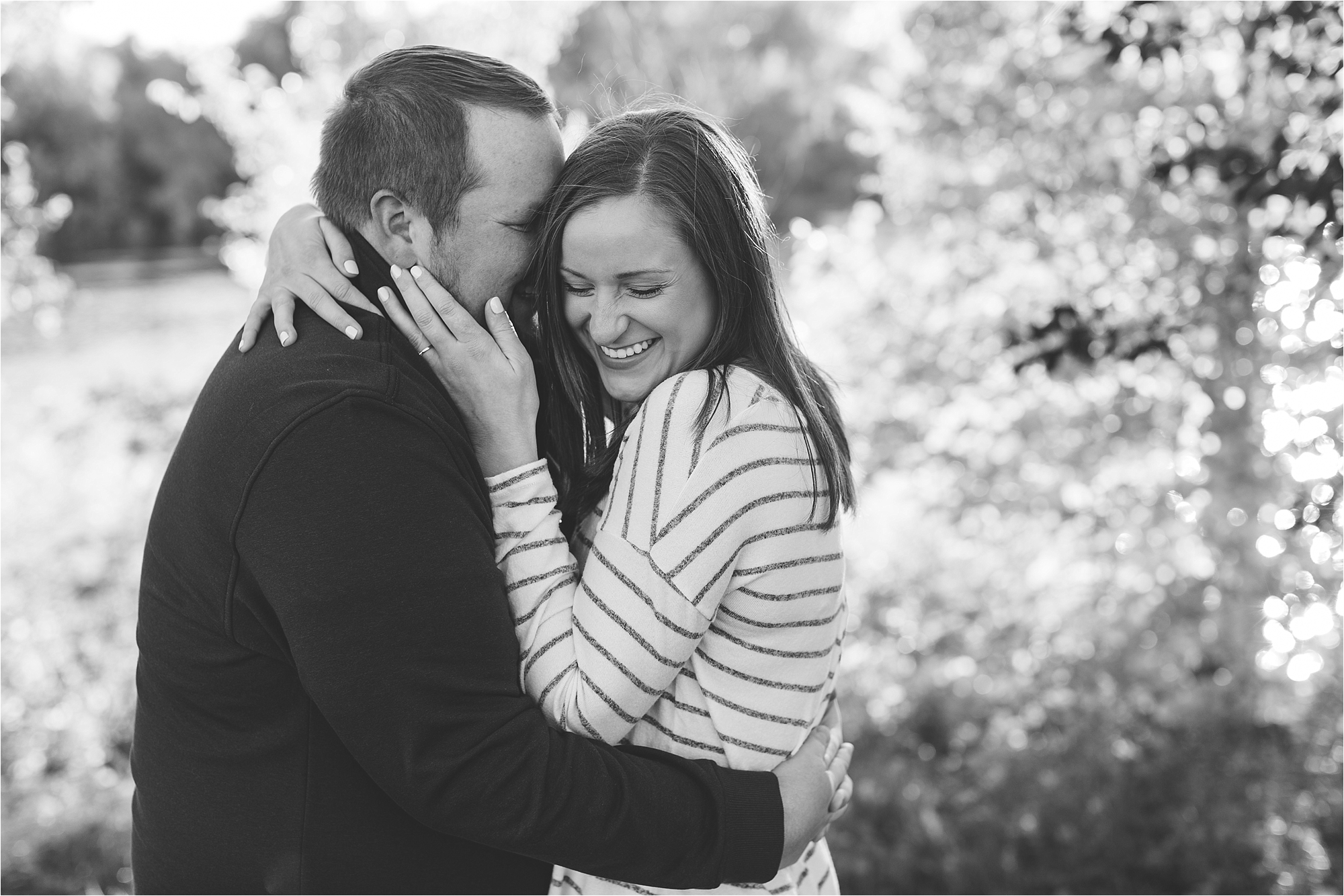 Black and white image of engaged couple embracing in Minneapolis fall engagement session at Boom Island Park in Minneapolis