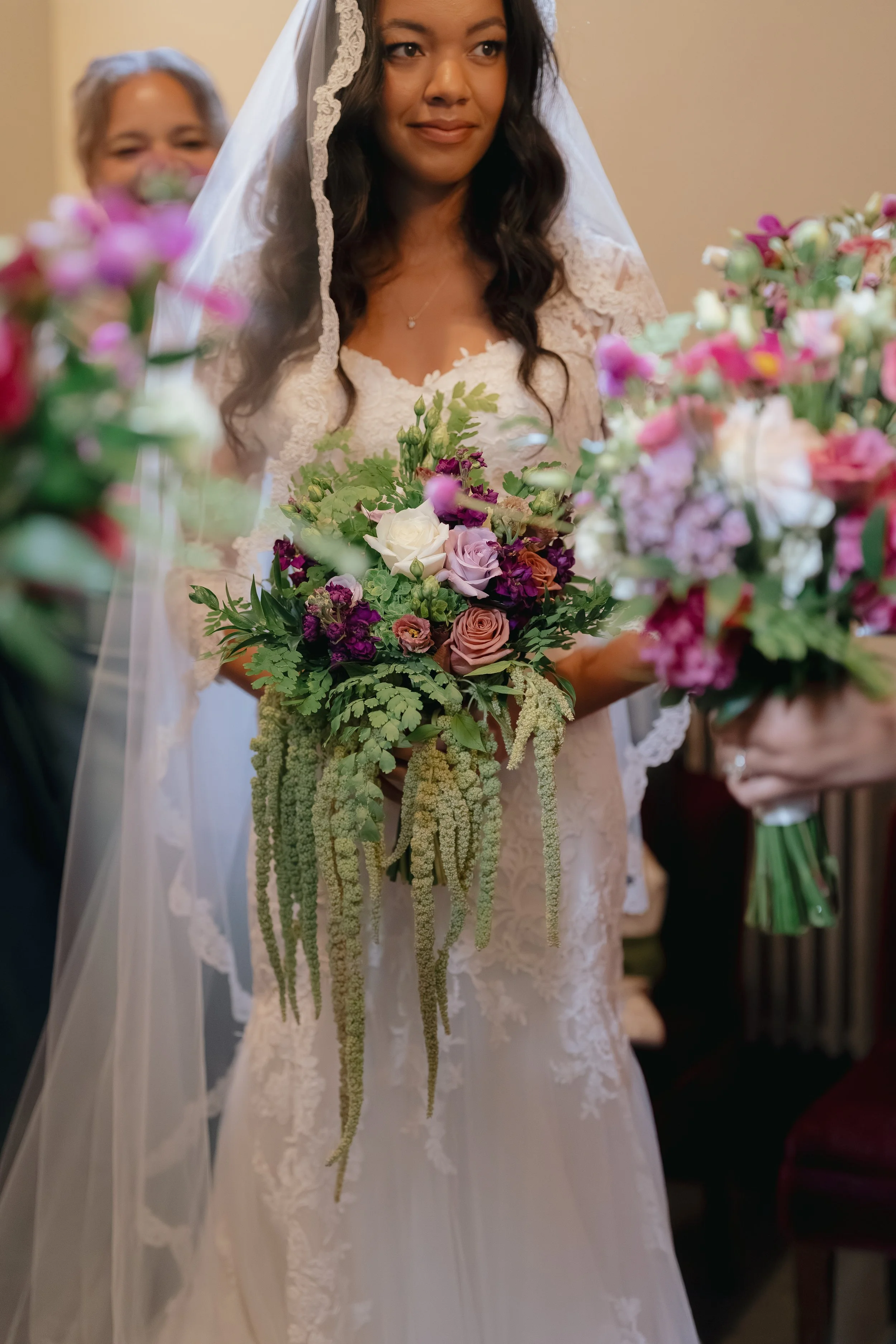 Close-up of a bridal bouquet featuring roses and cascading green amaranth for a modern, textured wedding floral design.