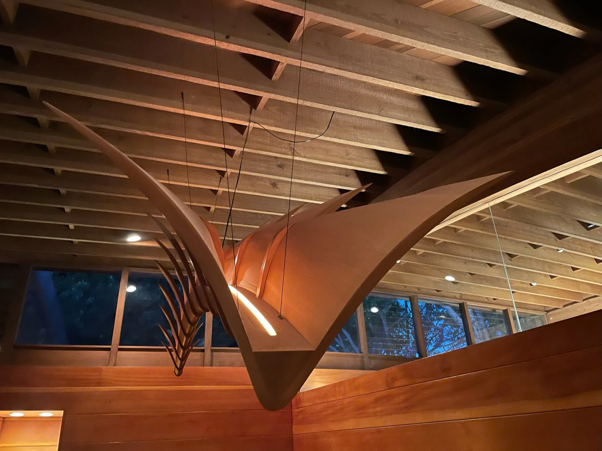 Detail of the internal linear LED lighting channel integrated inside the custom wood chandelier core.