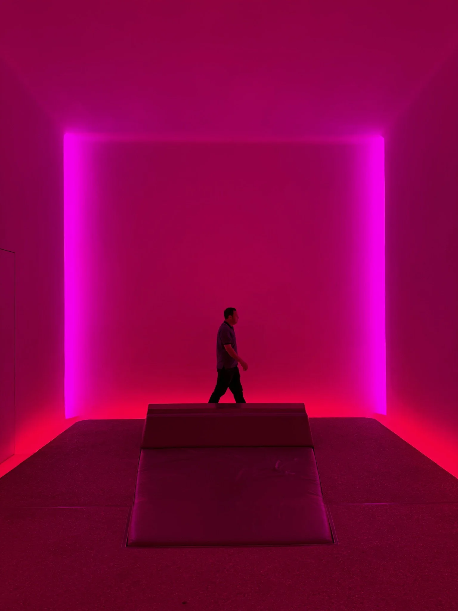 Interior view of James Turrell Skyspace 'Above Horizon' at Sheats-Goldstein Residence, with built-in cushioned floor lounge illuminated by colored LED lights from hidden alcoves – preserved by Conner & Perry Architects, Los Angeles