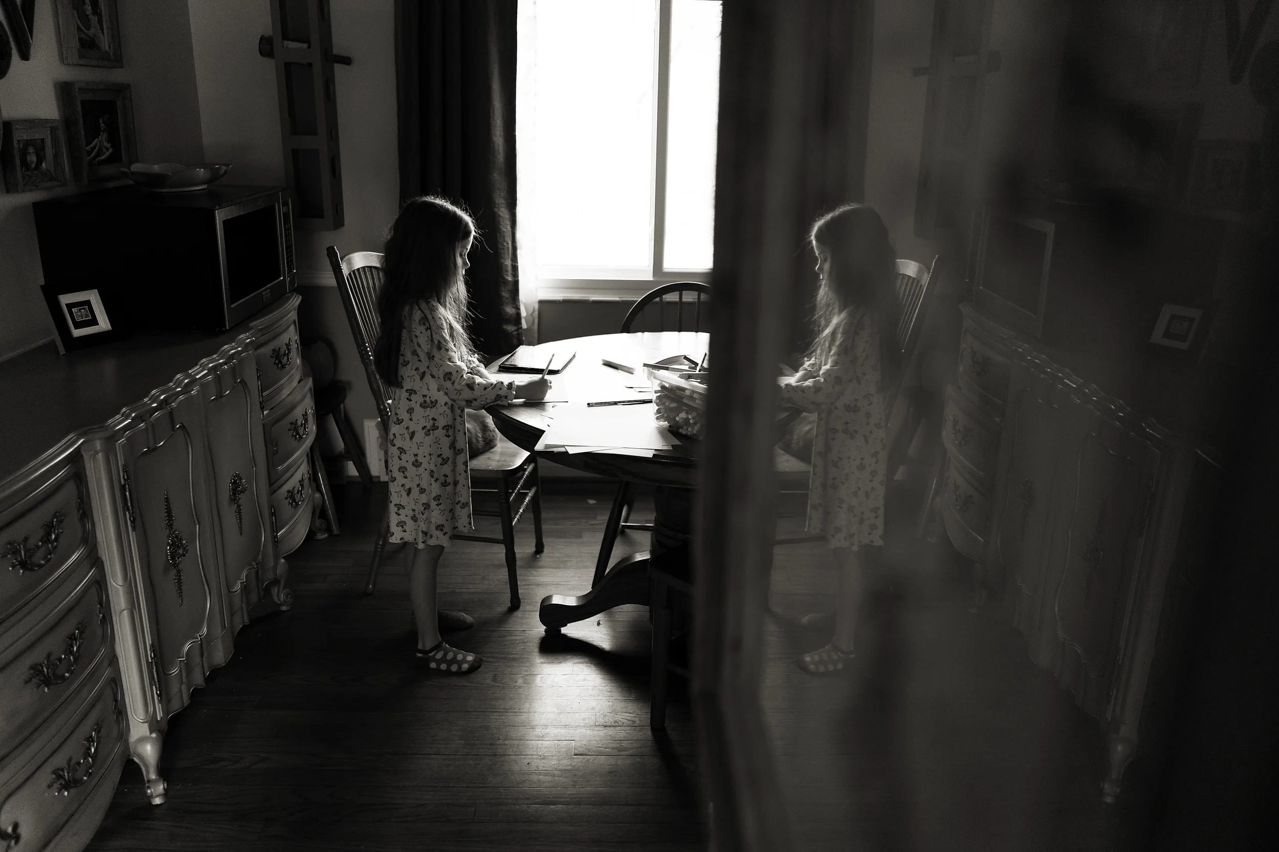 Columbus photographer captured 6 year old daughter drawing in Worthington home. Reflection with vintage furniture.