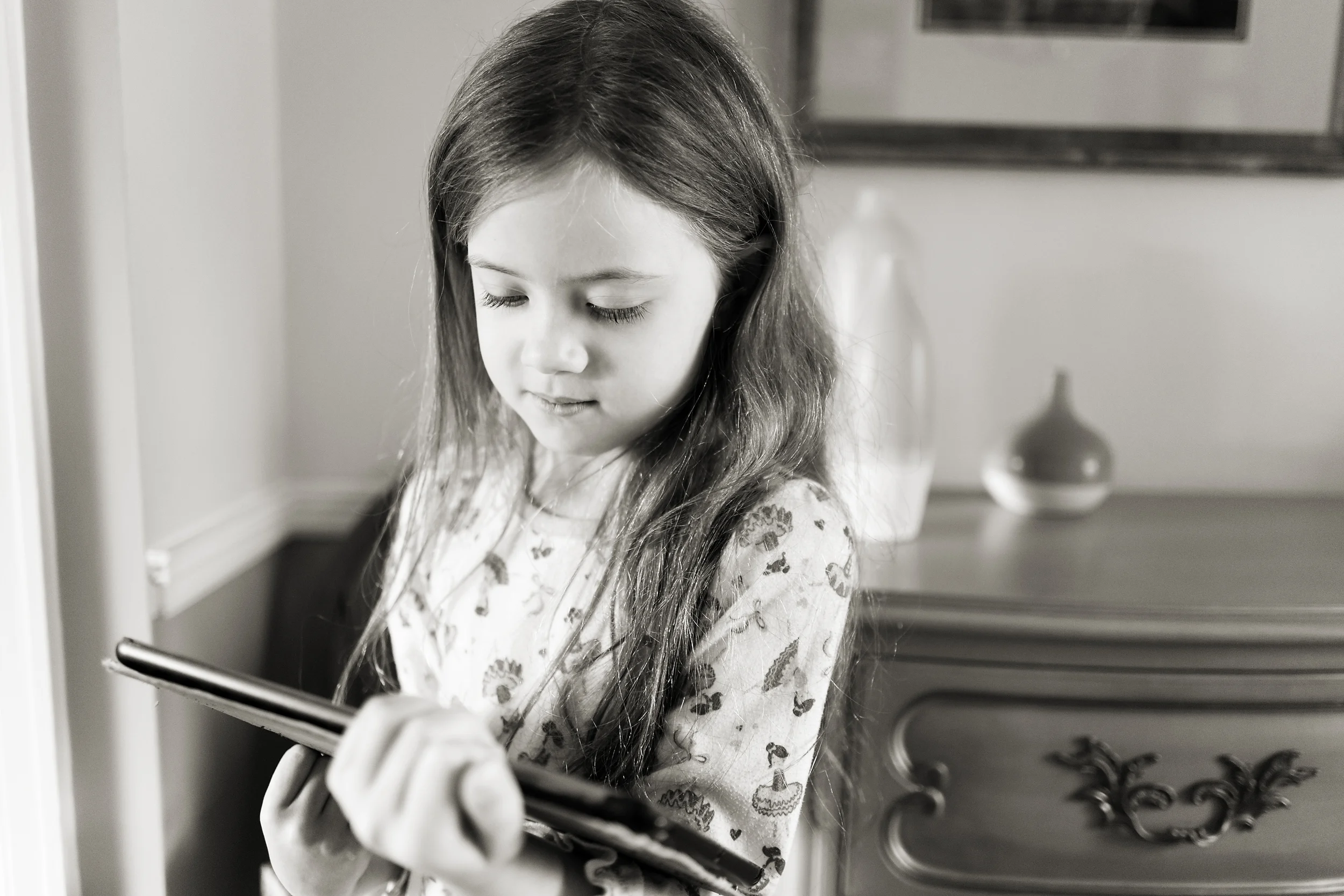 Child with long hair in pajamas with ipad in old home in Worthington, Oh. 