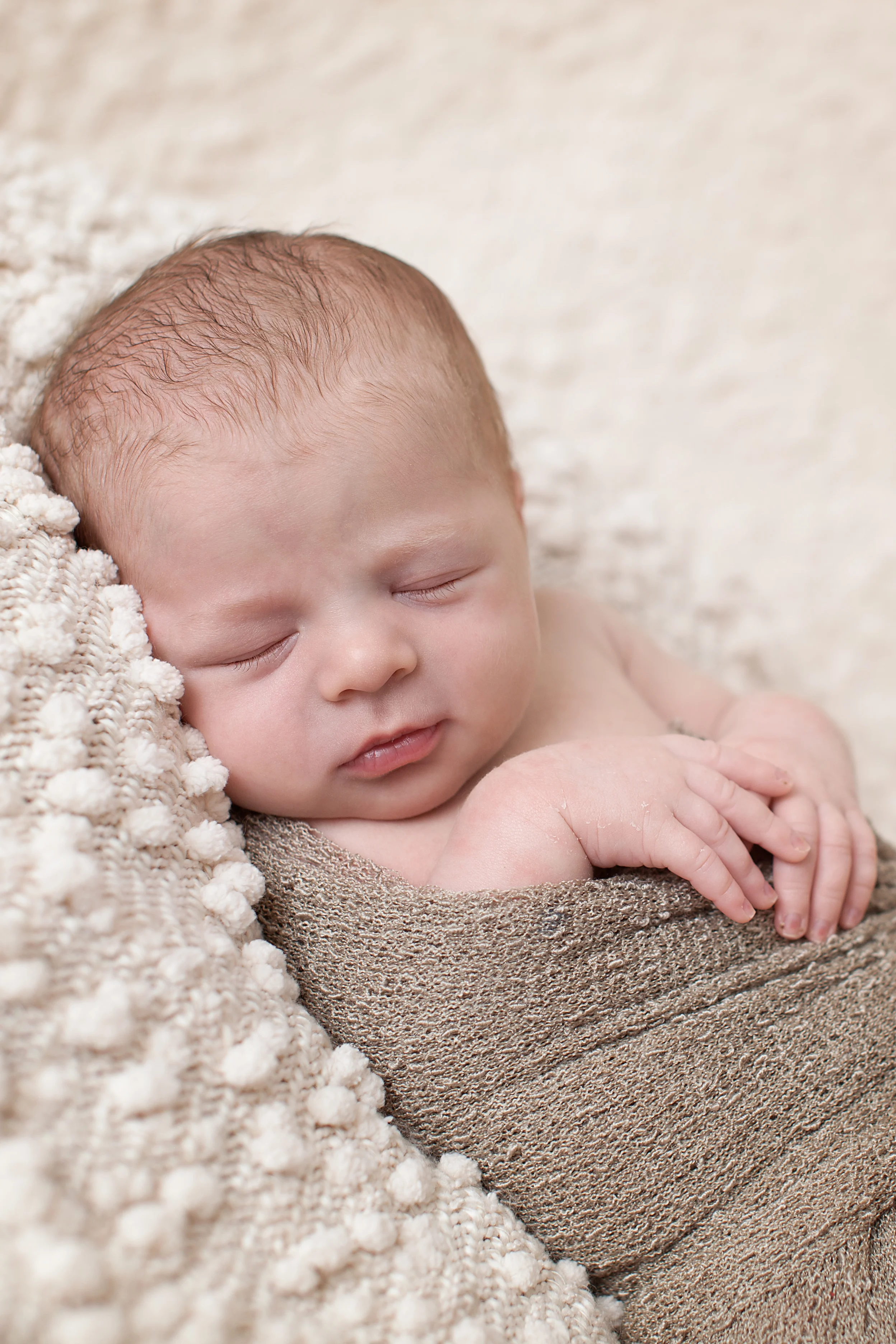 Columbus, Ohio photographer, Professional Portrait Studio, newborn photography. Infant in wrap with jewel tieback.