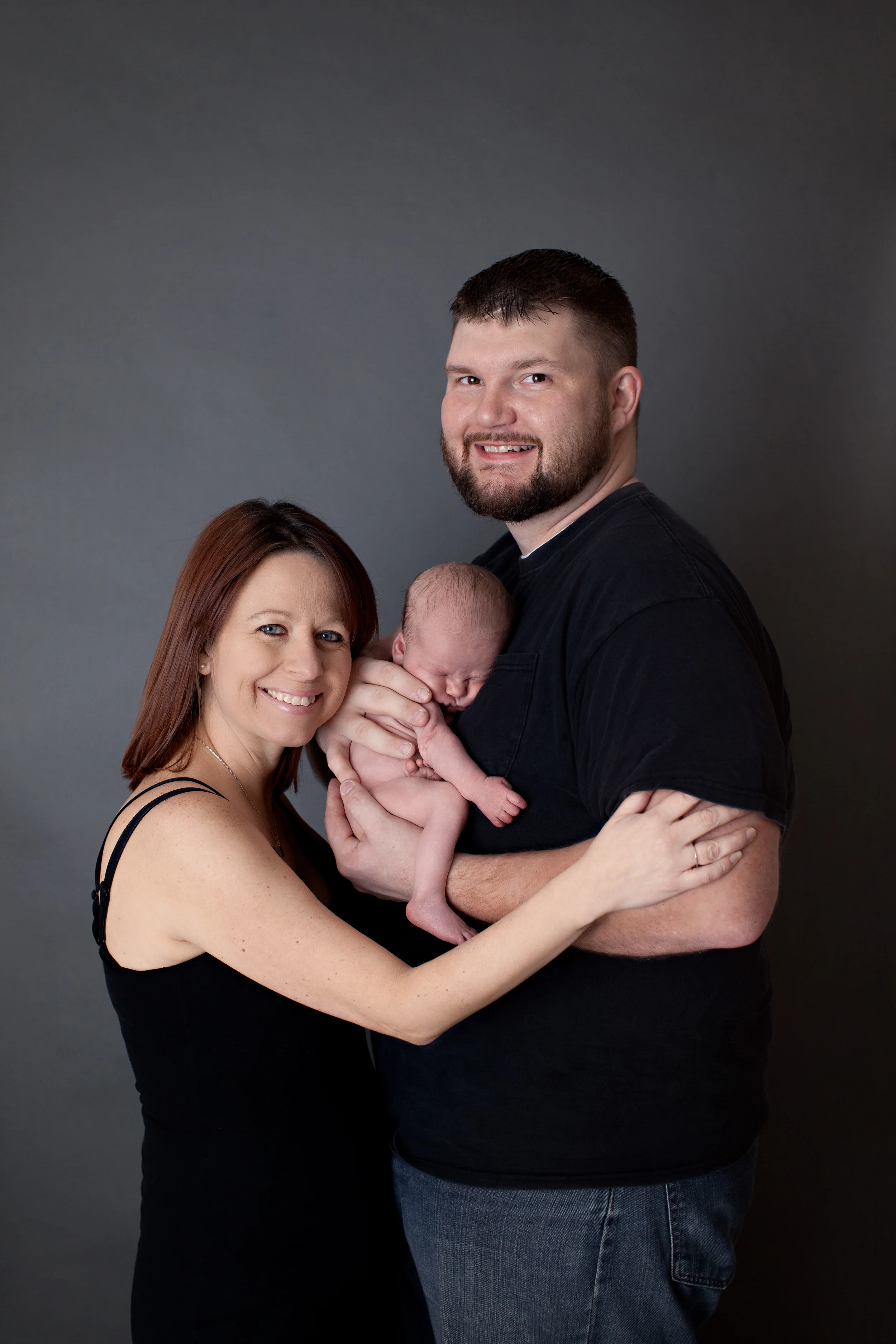 Columbus Ohio professional portrait photographer. Newborn baby photography. Mother and father with infant new baby.