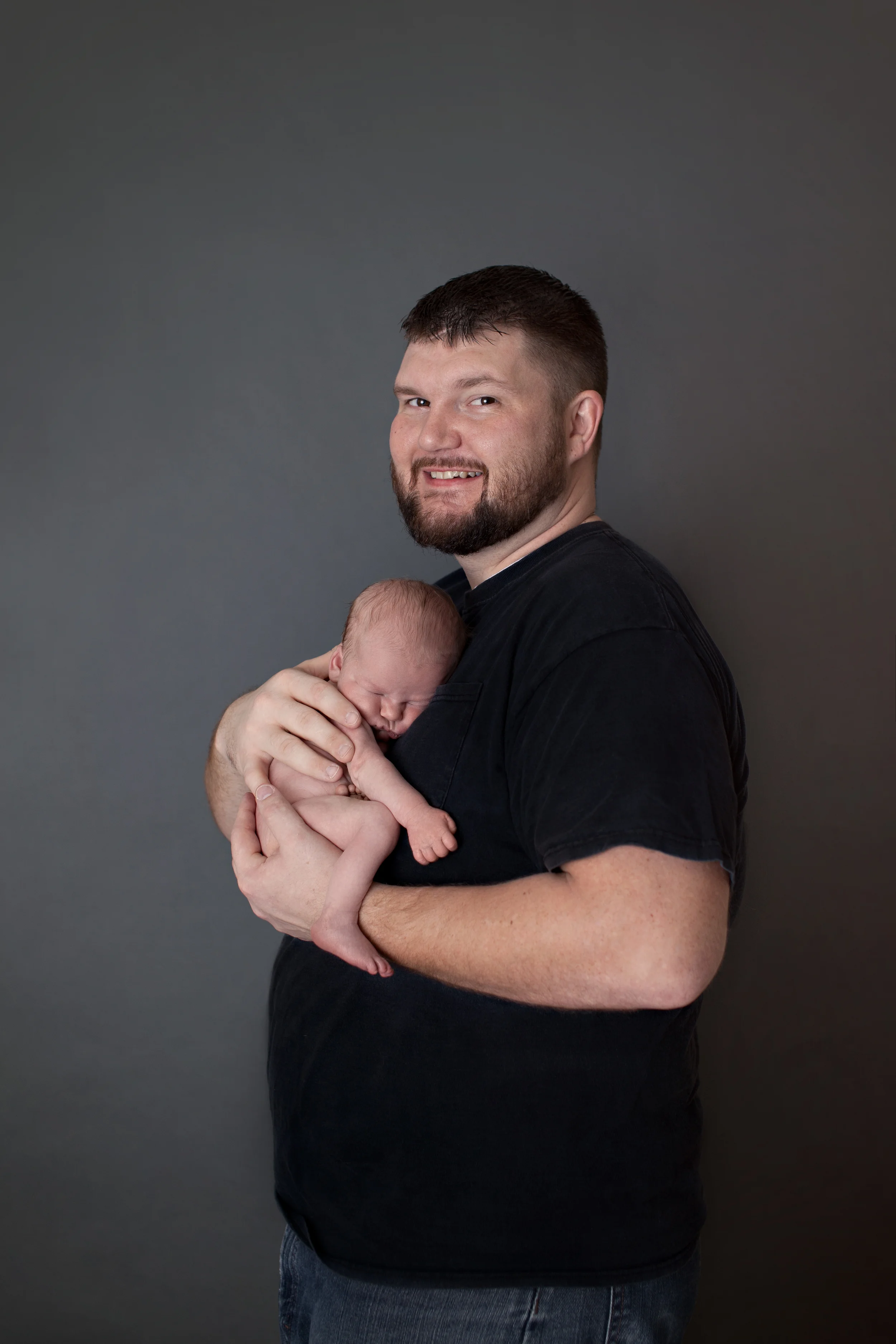 Columbus Ohio professional portrait photographer. Newborn baby photography. Infant baby in fathers hands. Studio location. 