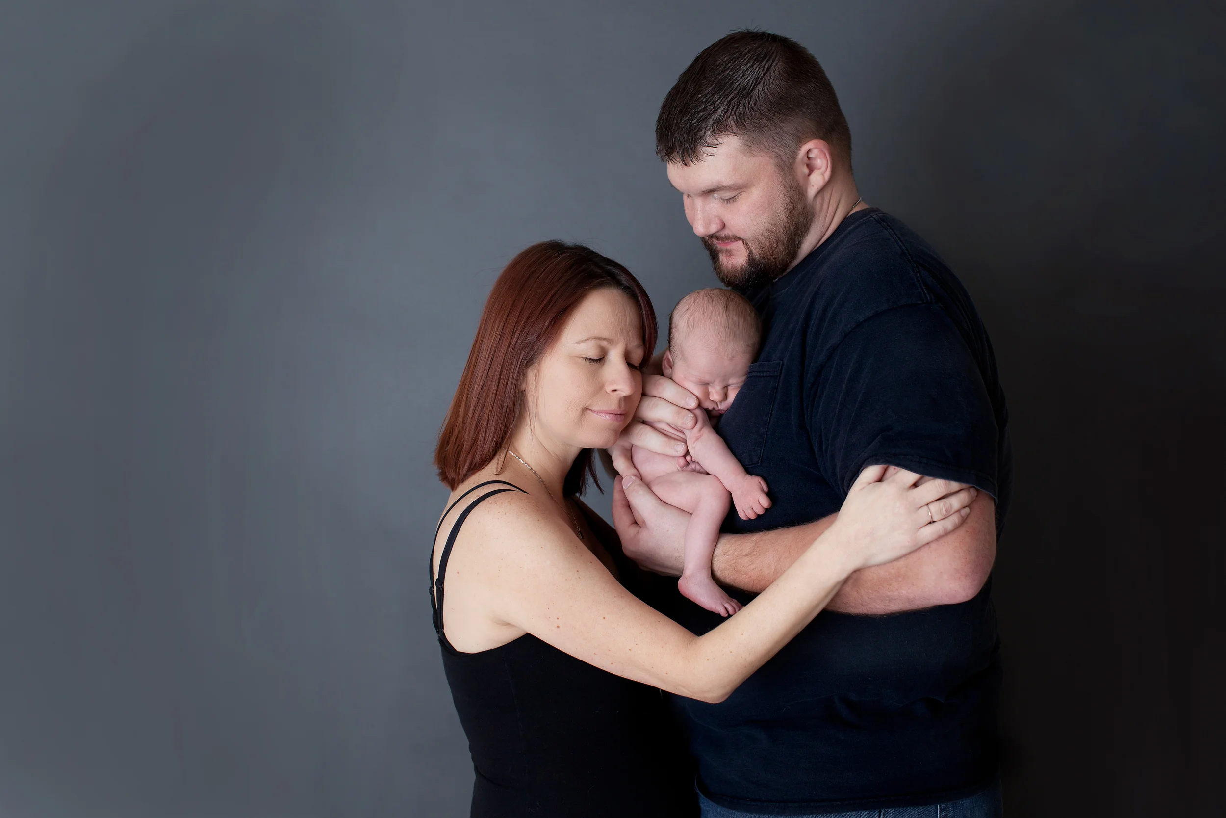 Columbus Ohio professional portrait photographer. Newborn baby photography. Mother and Father with infant son at Studio. 