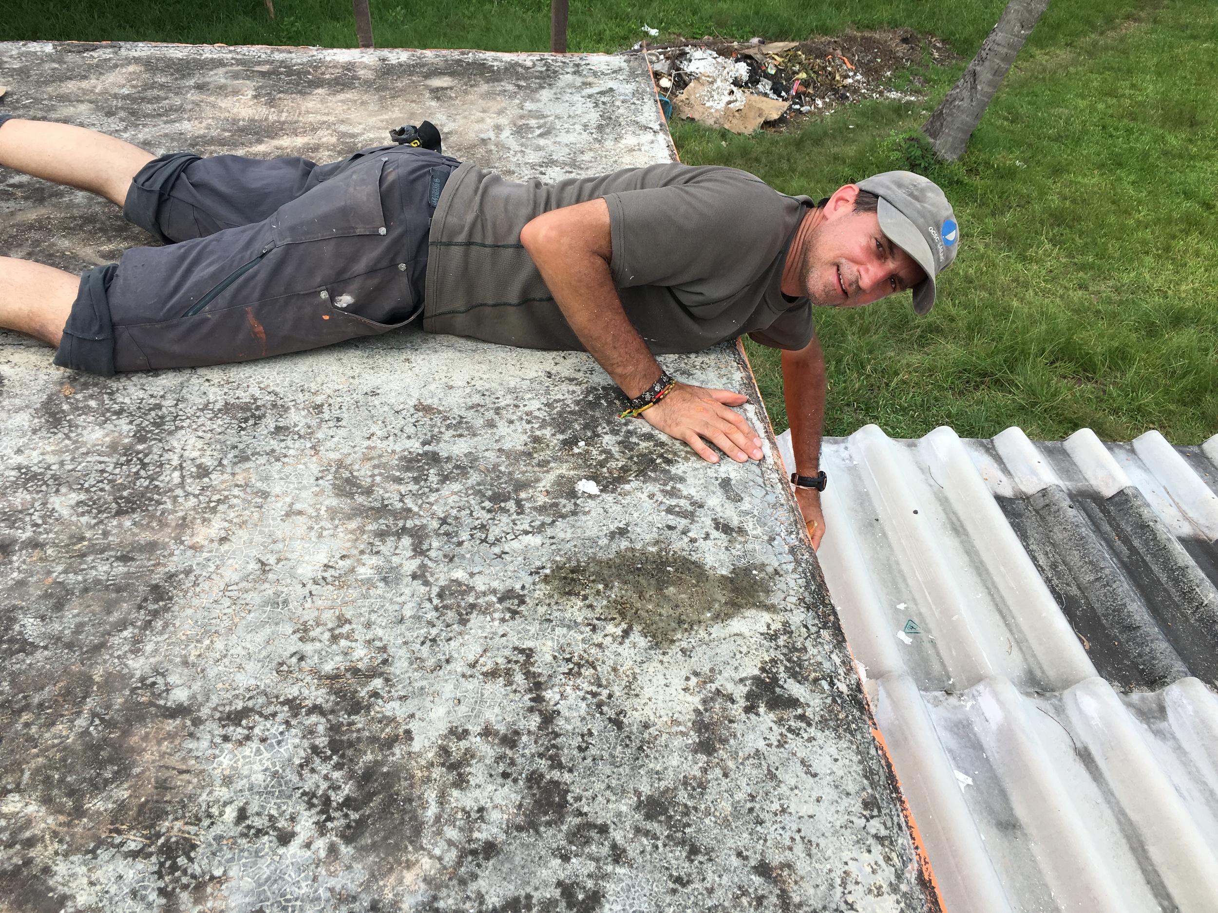 On the roof, painting upside down.