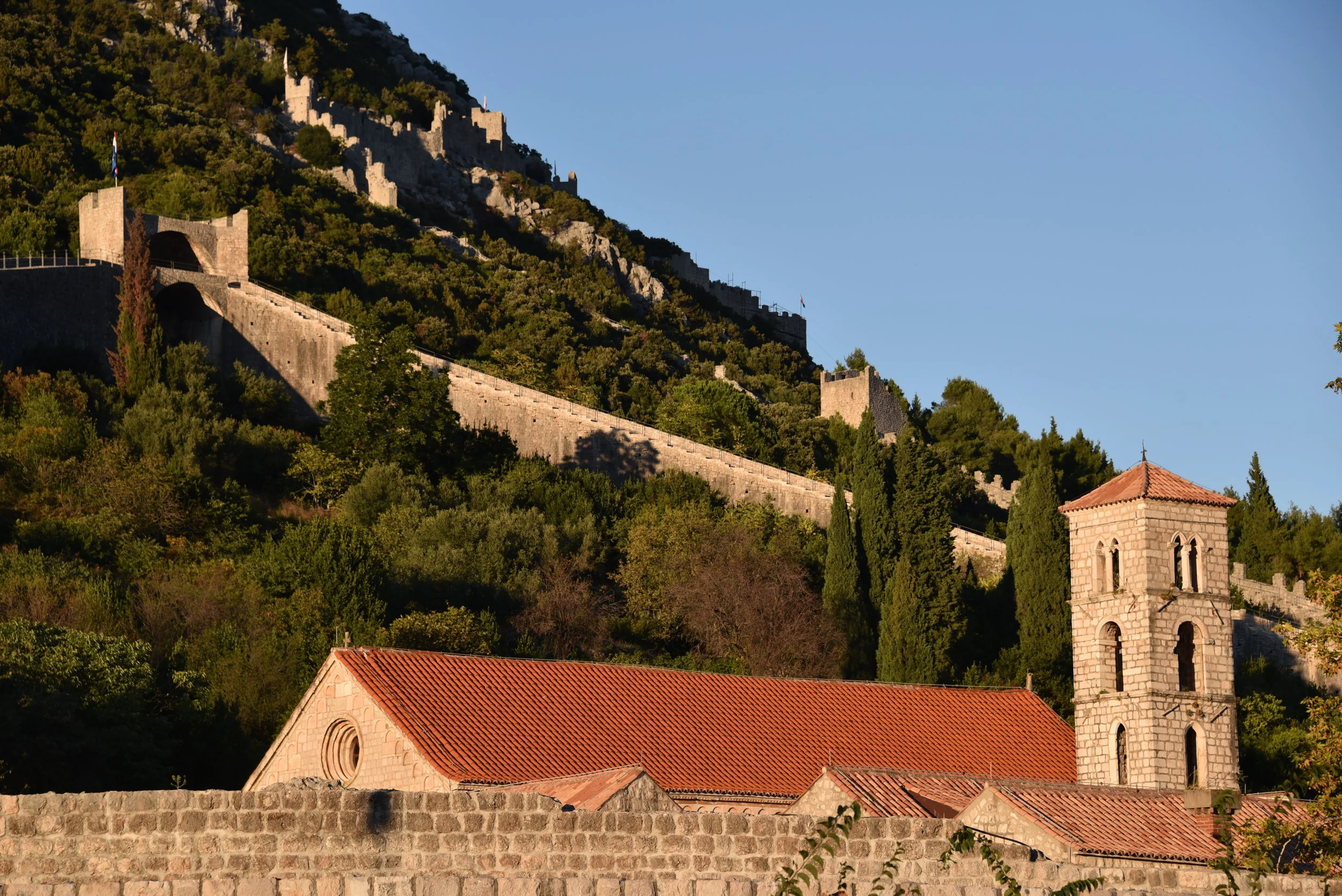 Walls of Ston at sunset, as viewed from outside the walls below.