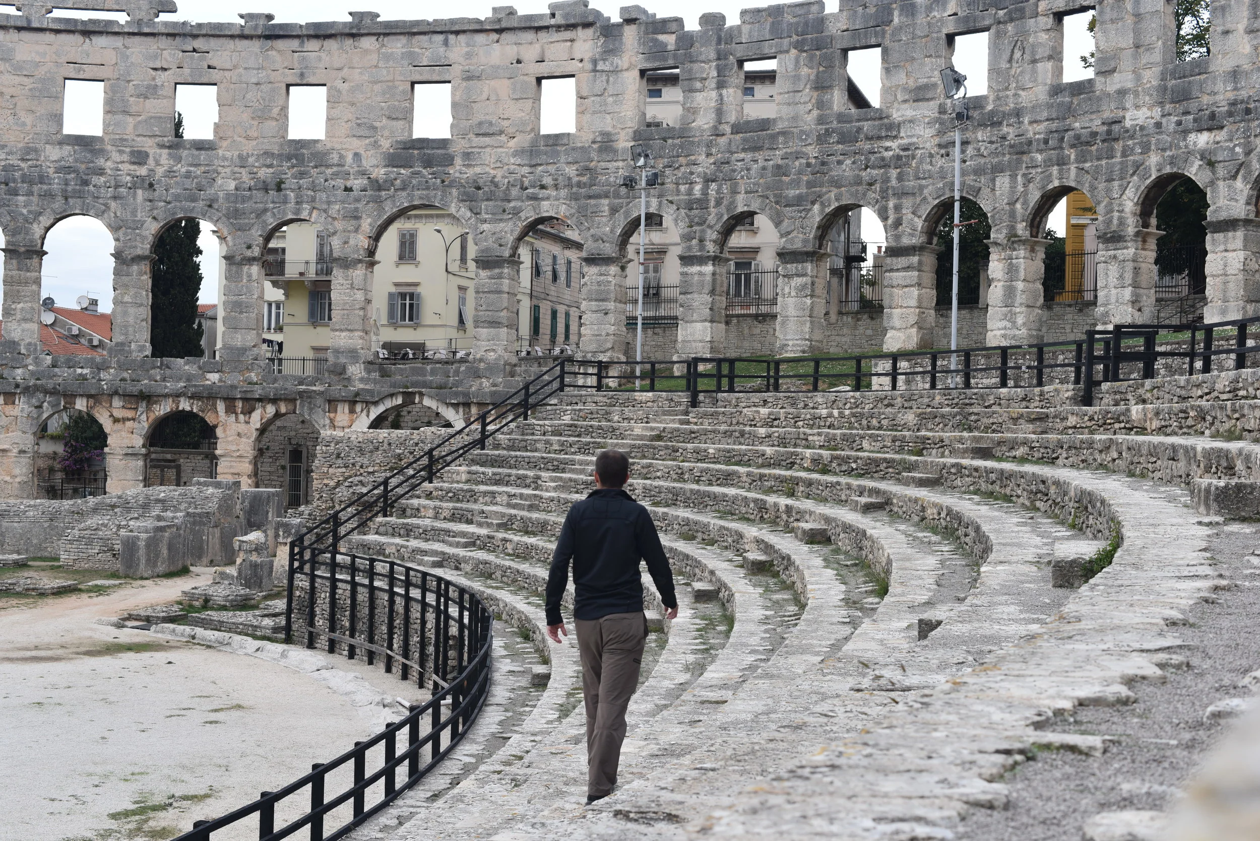 Walking along the seating area in the Pula Arena.