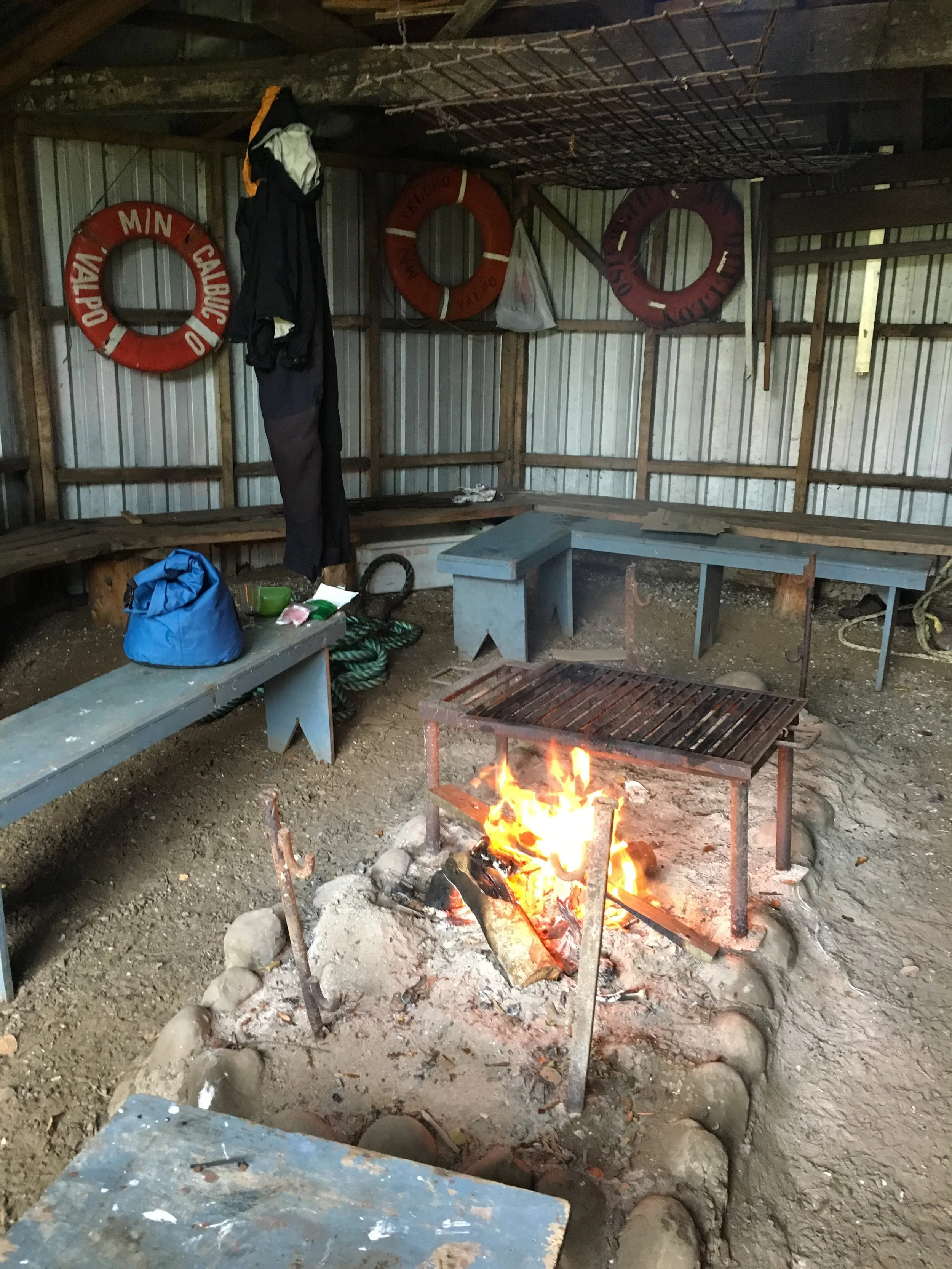 Getting the grill ready inside the quincho. Also drying my foul weather gear in the background.