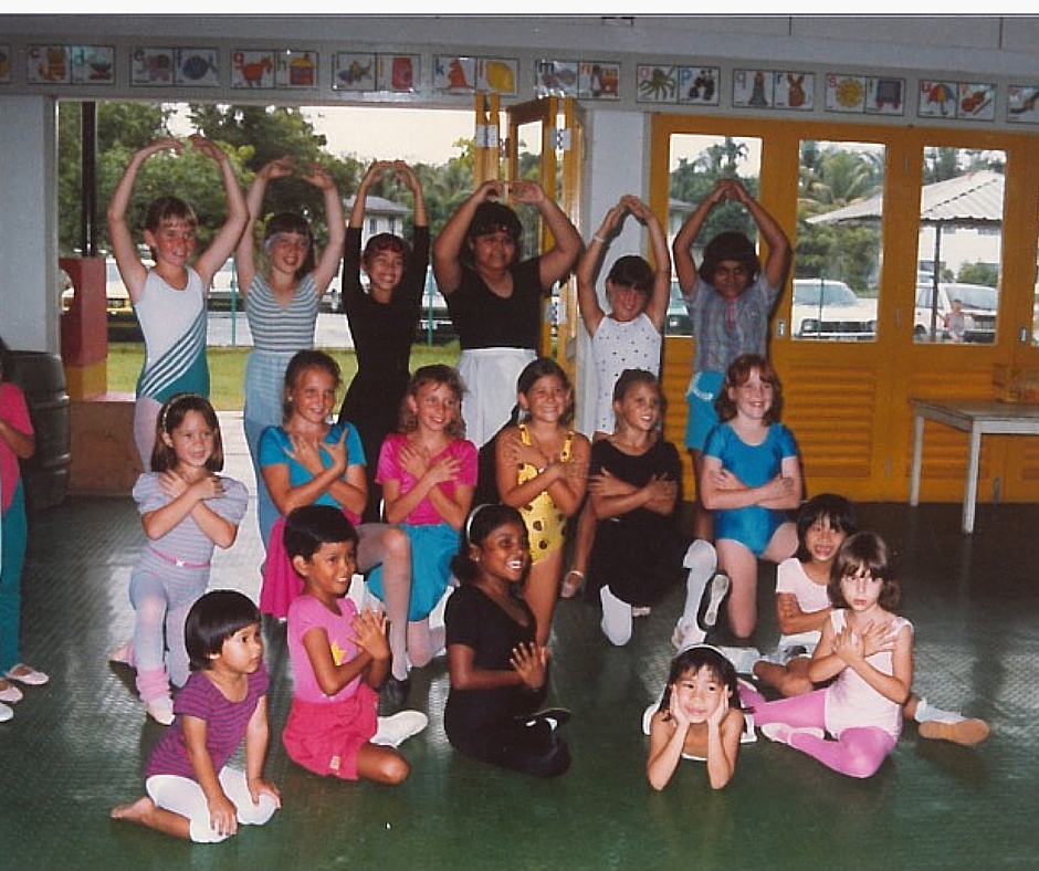 Jodie is the front row with her head in hands. She says "I look at this photo and it makes me smile, makes me realize that maybe I was born to always stand out. This was taken in my dance class in Brunei."