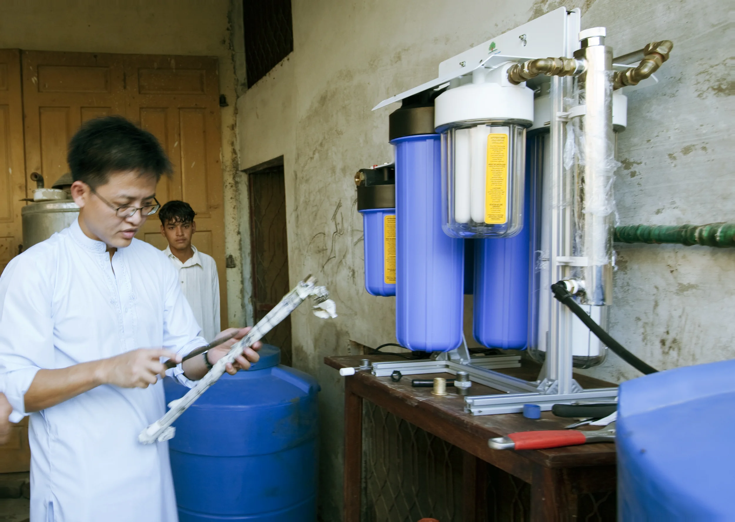 Malakand, Pakistan - August 2010 : Singapore humanitarian team assembling a water filter for the refugees. Other items donated include food supplies.