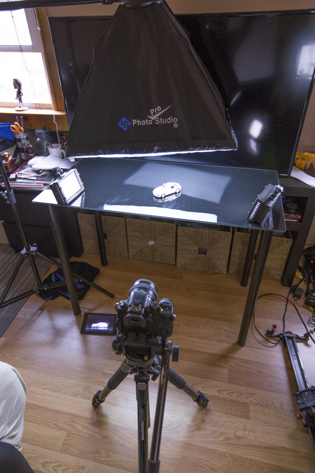 This is the setup on my glass computer desk with a softbox above, 2 LEDs, and my TV as the backdrop.