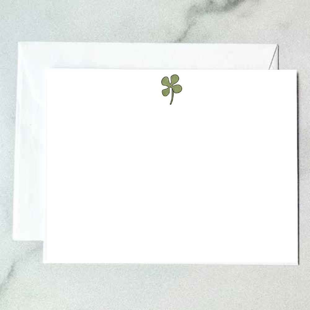 Illustrated green clover note card with a single delicate three-leaf clover on a stem on a clean white background, designed by Viola and Beatrice Stationers