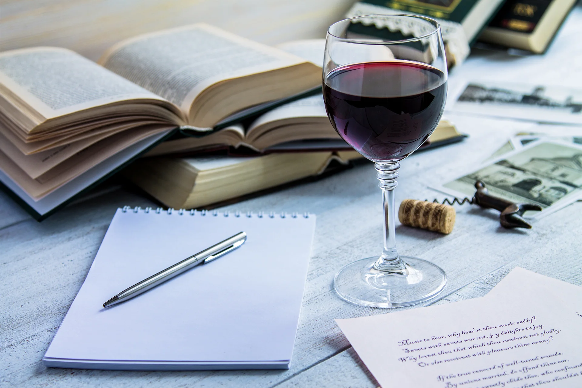 Glass of red wine and a book on a white wooden background-1.jpg