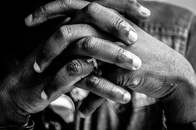 person's hands together in prayer