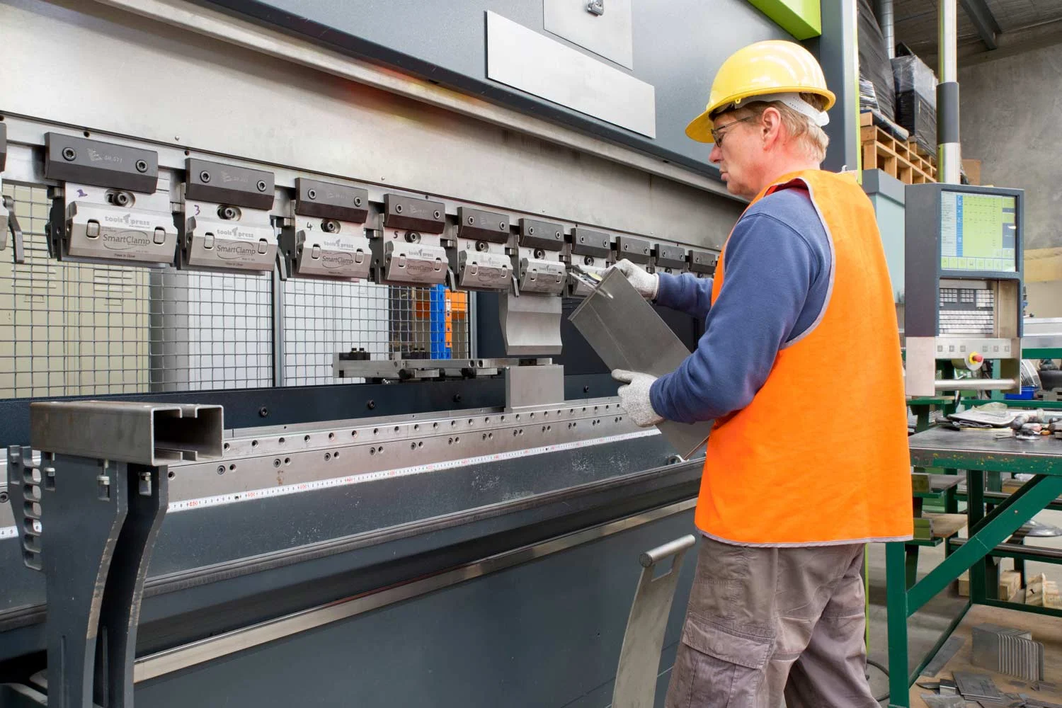 press-brake-with-operator-measuring-bend-accuracy.jpg