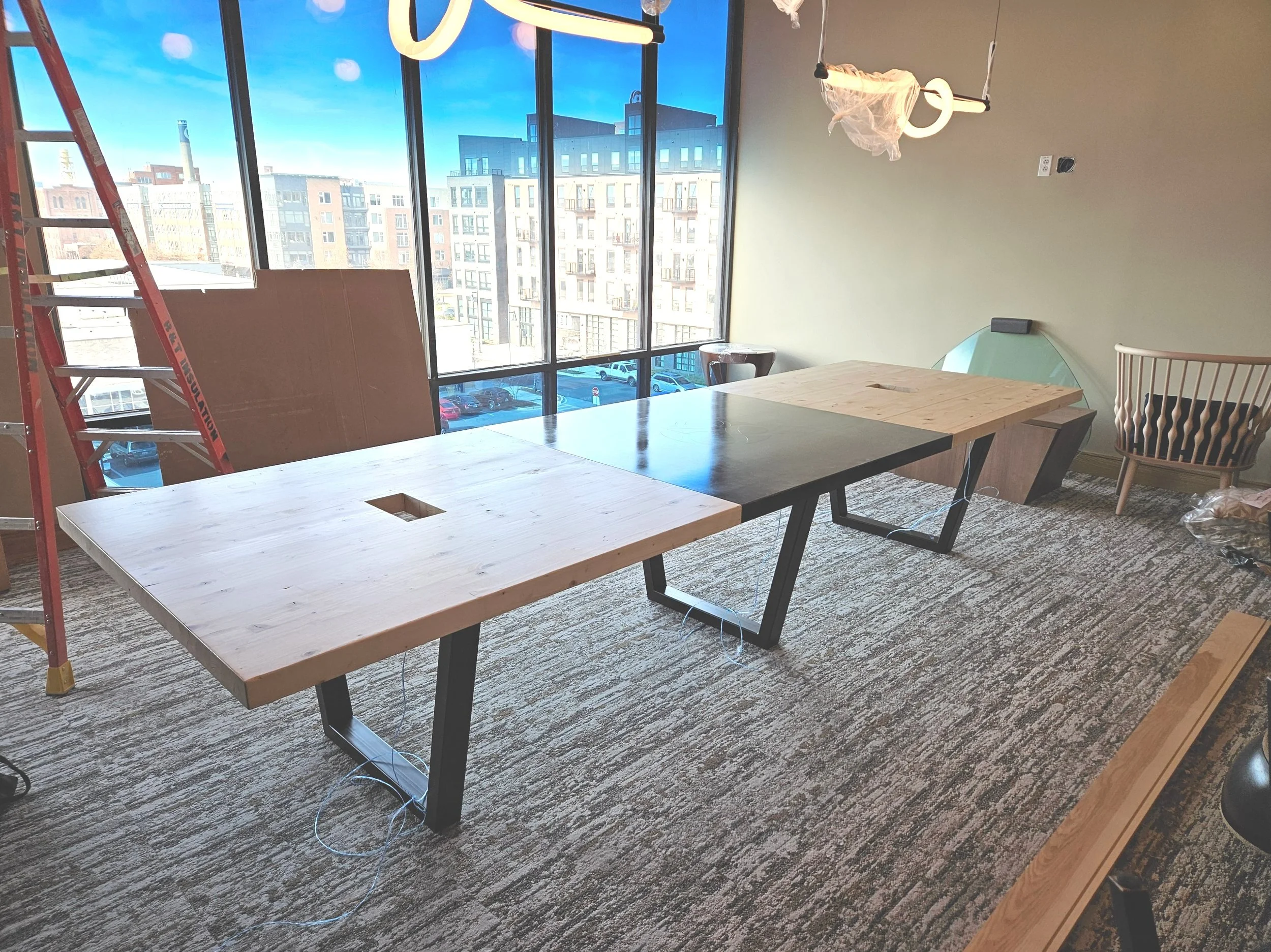 wood and steel conference table with large logo and cable management outlets