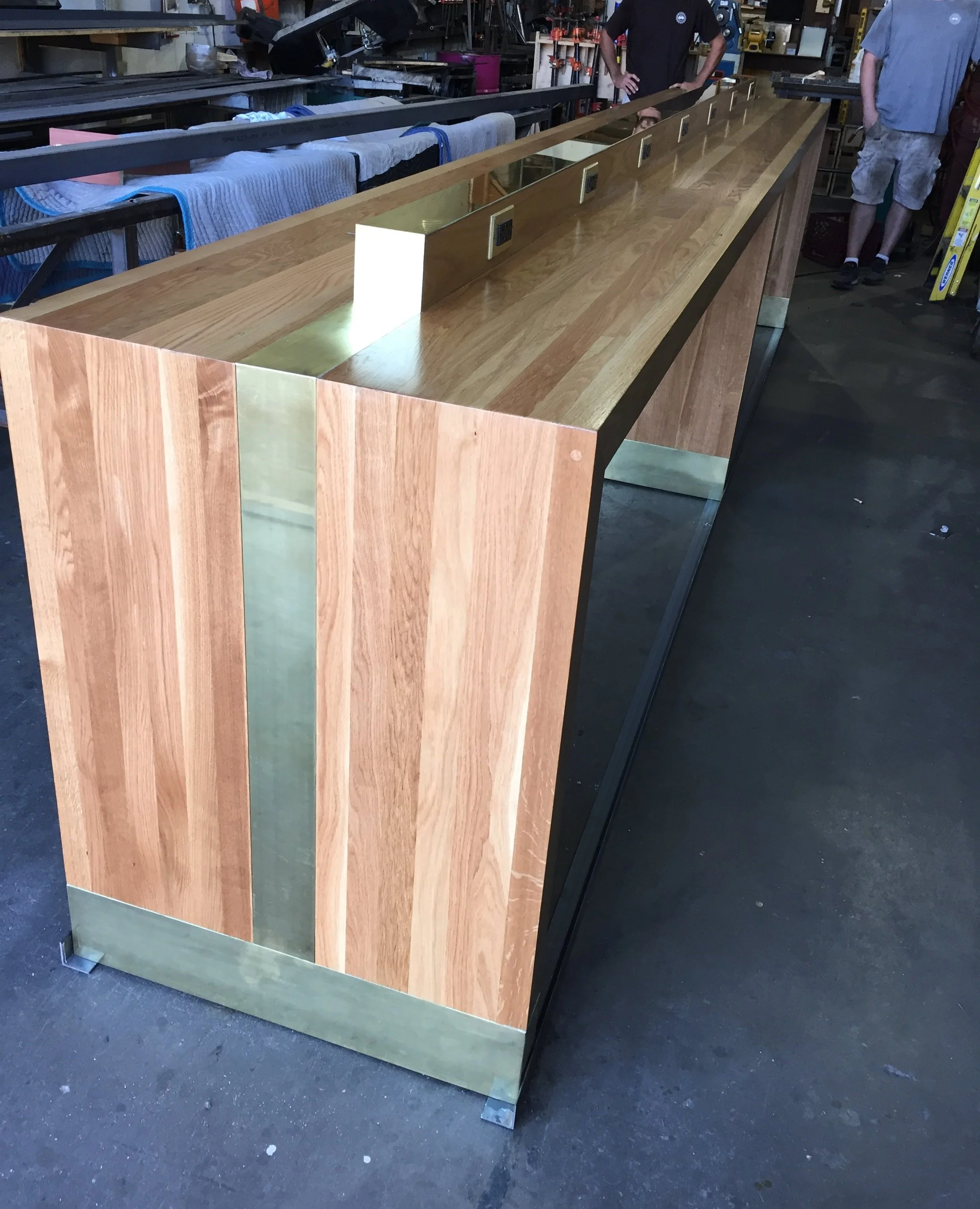 waterfall parsons bar table, integraed outlets, brass inlay, brass accents, baltimore maryland custom woodworking metalworking, co working space, airport lounge