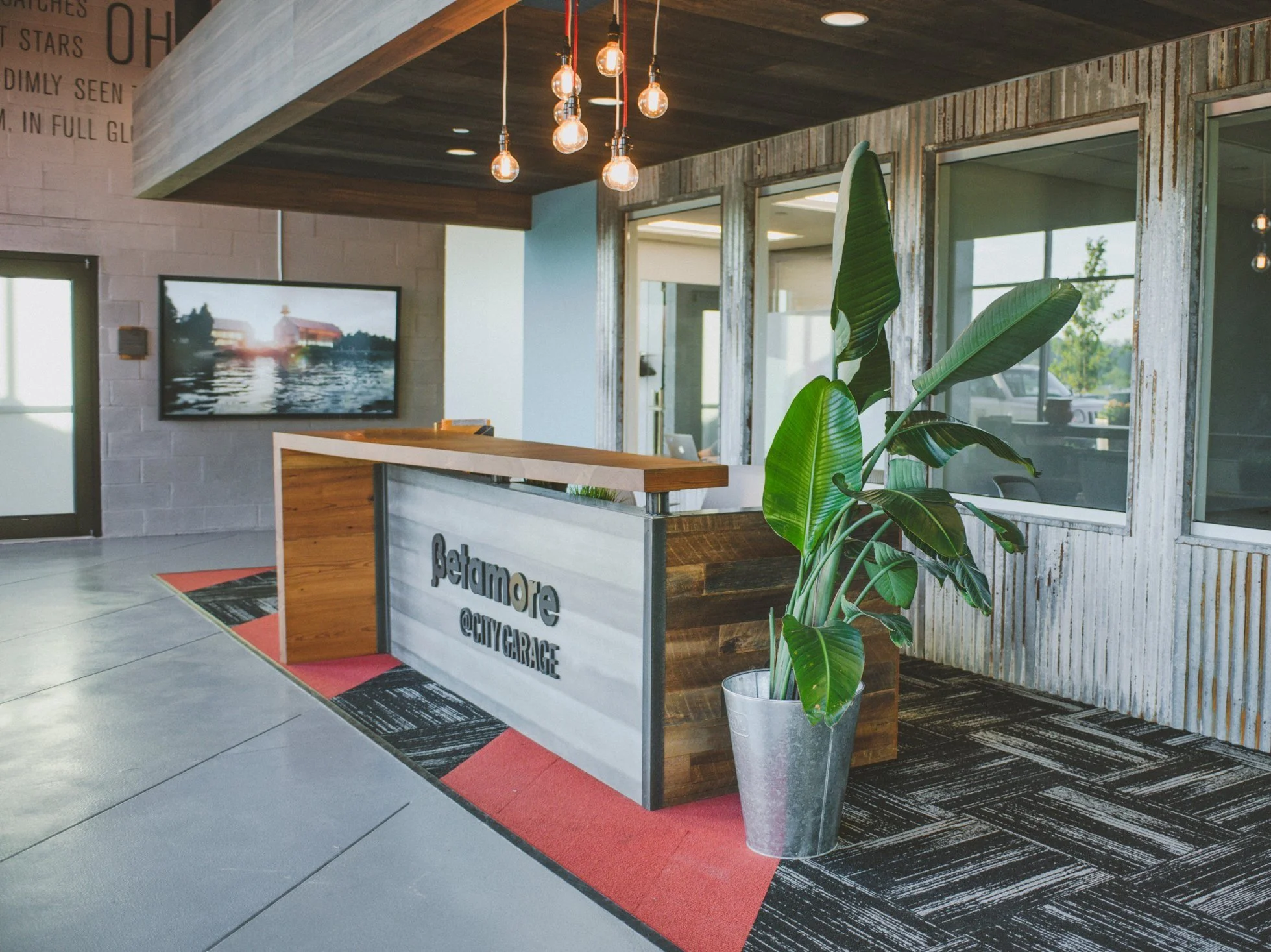 modern insdustrial recpetion desk, zinc panels with reclaimed wood counter and logo