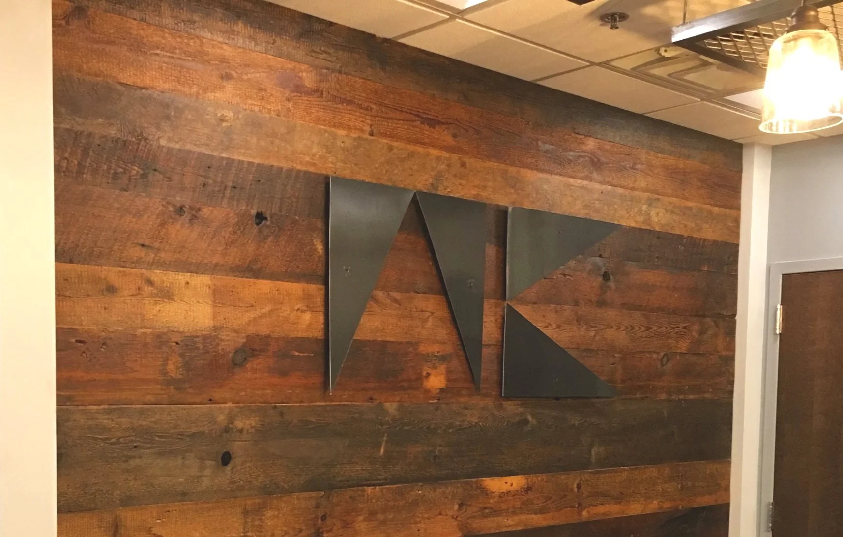 reclaimed wood accnet wall with 3d company logo blackened steel