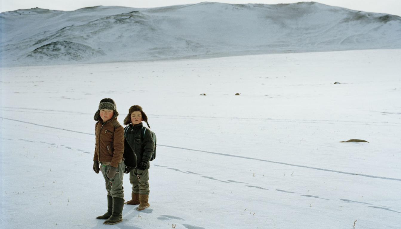 Two schoolboys, wearing fur-lined boots, walk home through the snow near the village of Altai (Алтай) in the far west of Mongolia.