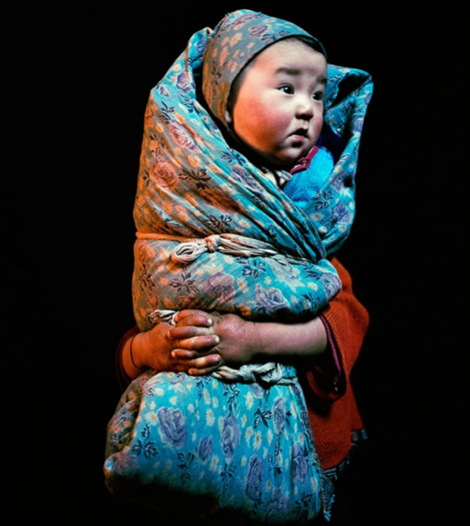 Wrapped baby, held by his sister, at Üüreg Lake in western Mongolia.