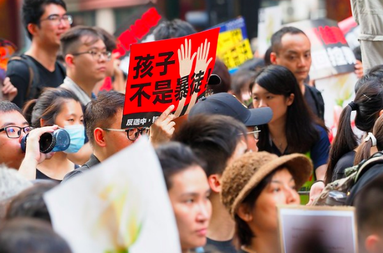 Holding a sign that reads “kids are not rioters.” Etan Liam. CC BY-ND 2.0