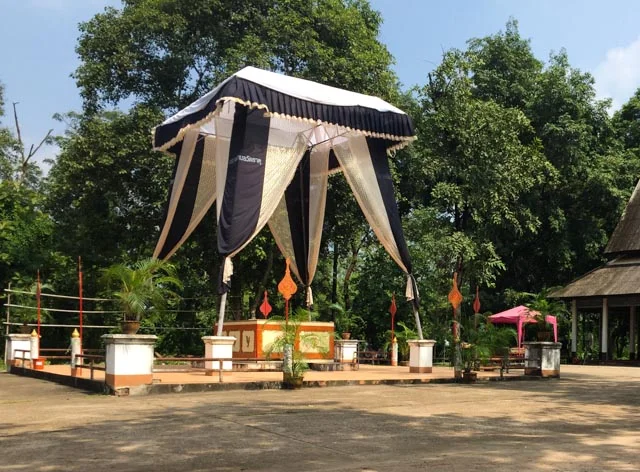 The casket is placed on the raised area underneath the tent, after the funeral it is lowered into the cremation area.