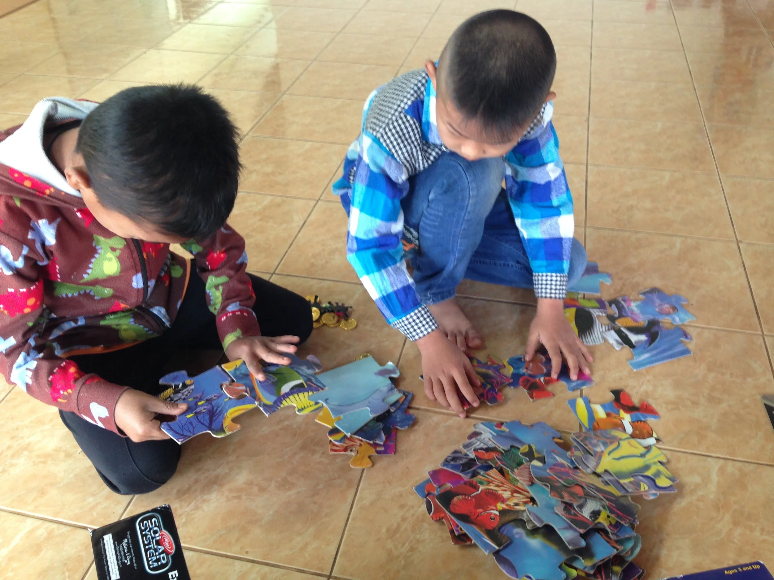 Young boys working hard on a puzzle at an event we helped with last Saturday