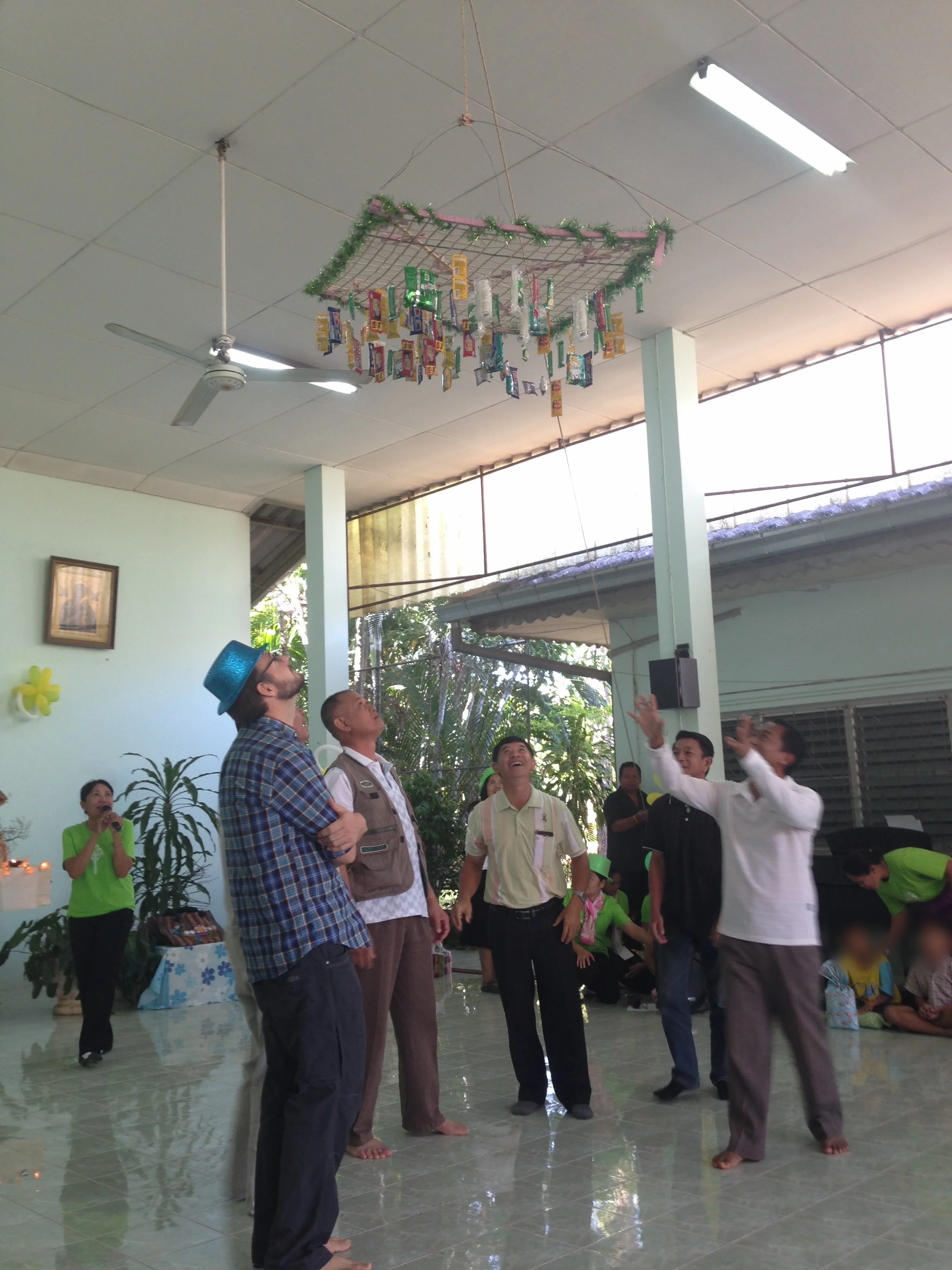 The male staff vie for prizes from a moving apparatus.
