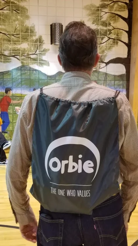 Board member, Brian, models the Orbie backpacks for the kids.