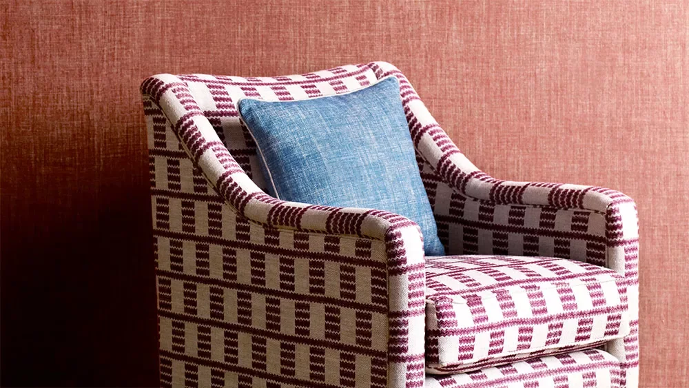 a-red-cove-chair-against-red-fabric-wallpaper.jpg.webp