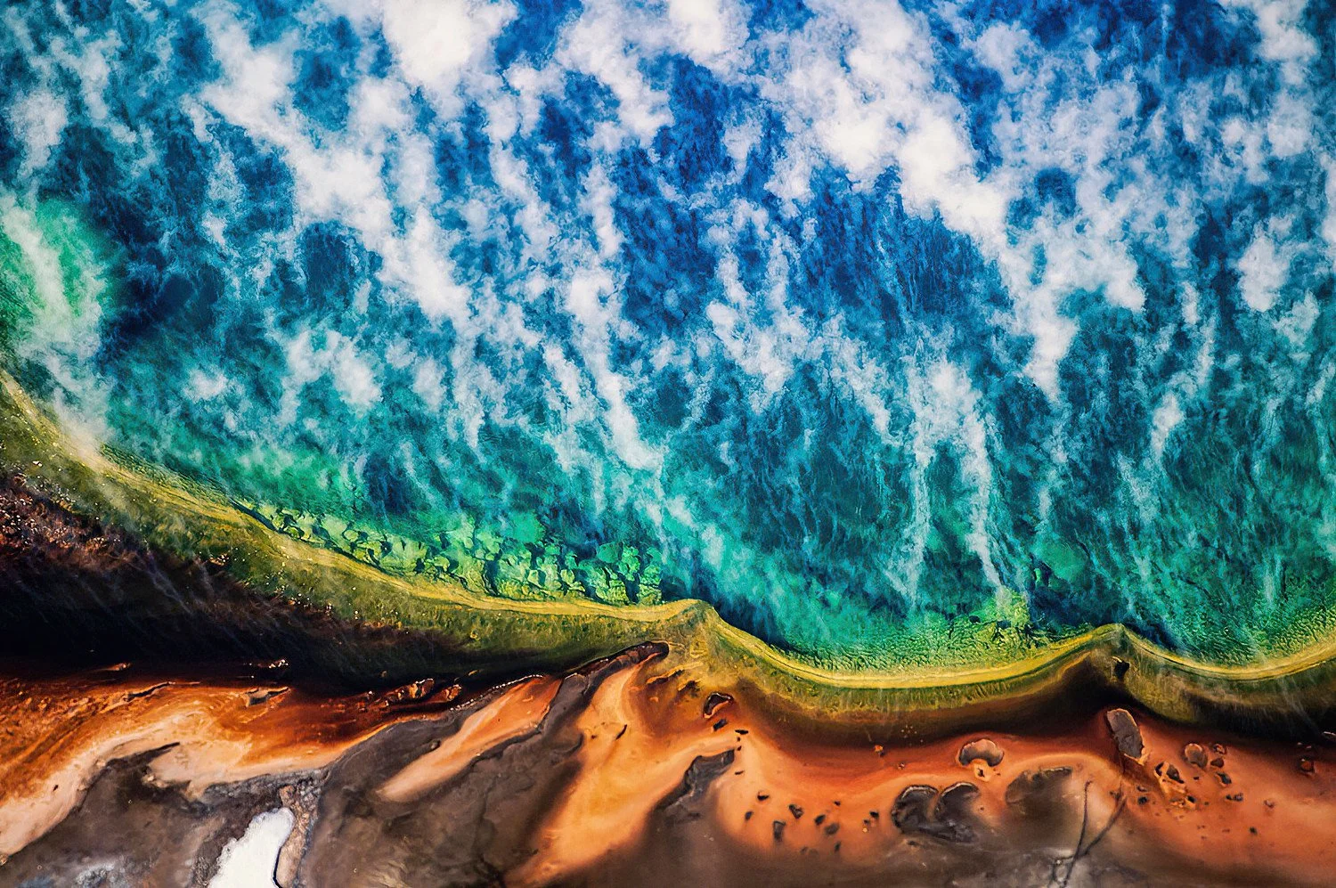 An aerial photo of the Grand Prismatic, Yellowstone Park, Wyoming, USA.  It is the largest hot spring in the United States, famous for its vivid rainbow-colored rings caused by heat-loving microbes.