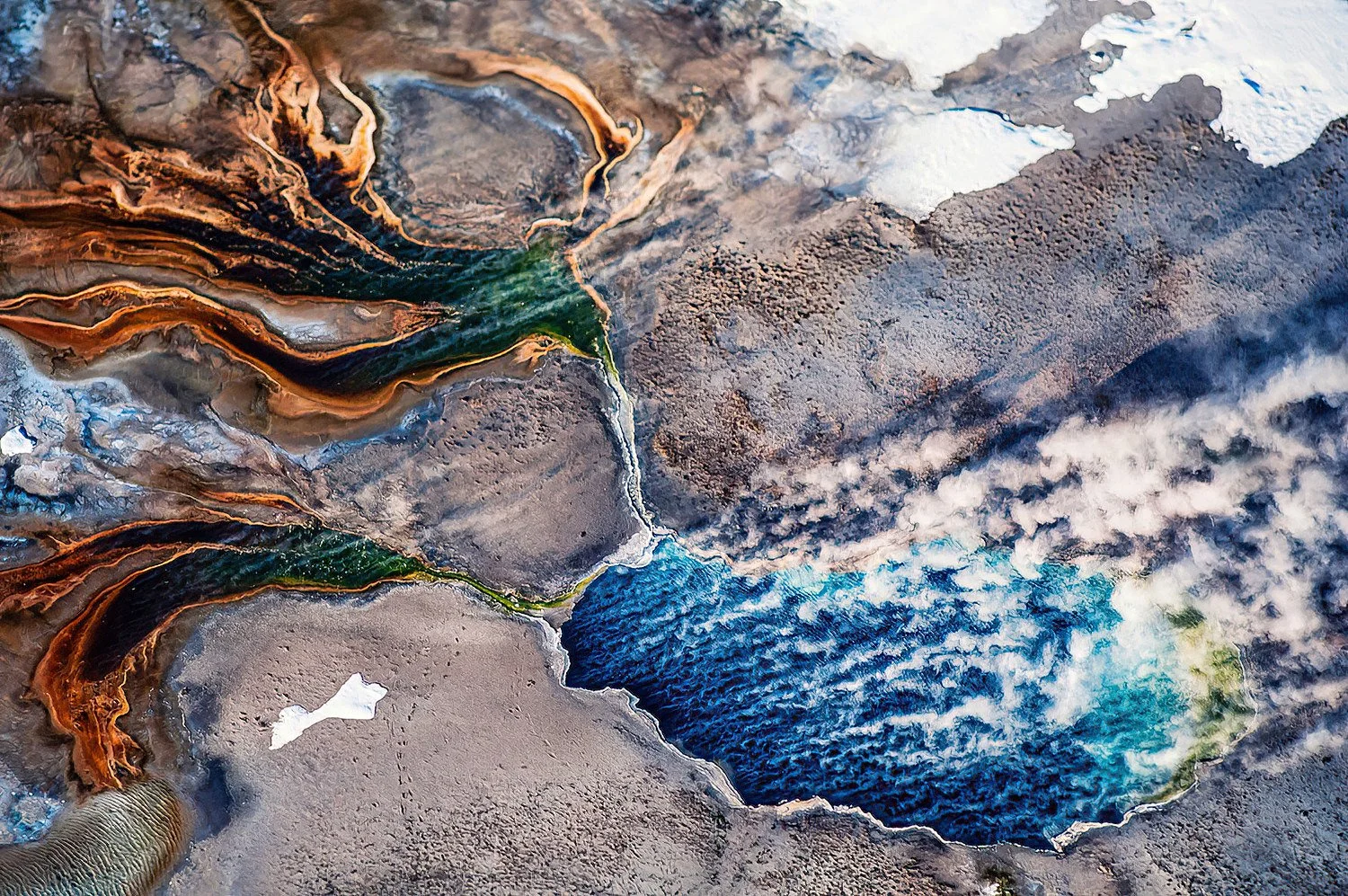 An aerial photo of a thermal pool, Yellowstone Park, Wyoming, USA.  Yellowstone has over 10,000 thermal features—the largest concentration on Earth—because it sits atop a massive volcanic hotspot.