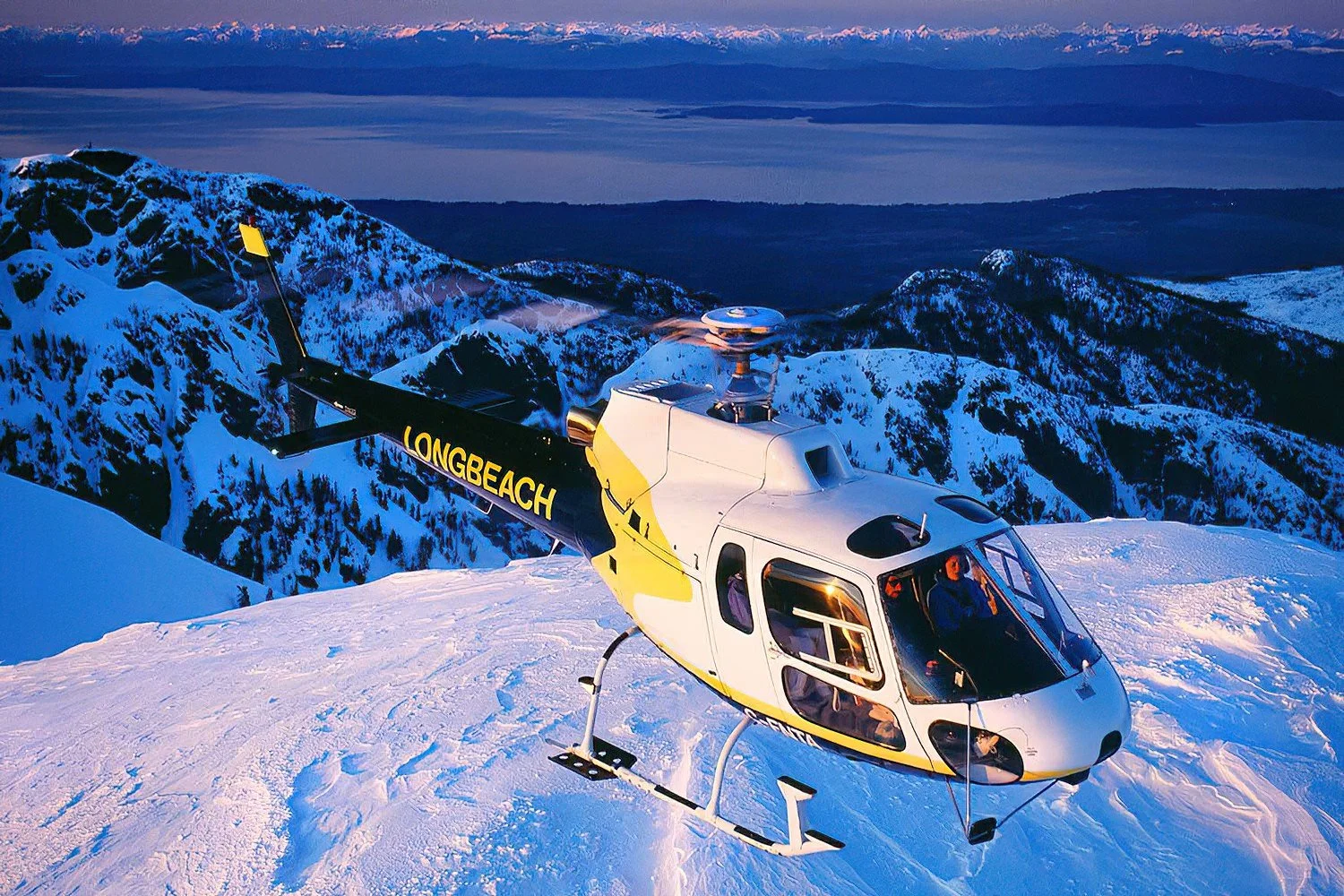 An aerial photo of a Eurocopter AS350 helicopter over Vancouver Island, BC, Canada